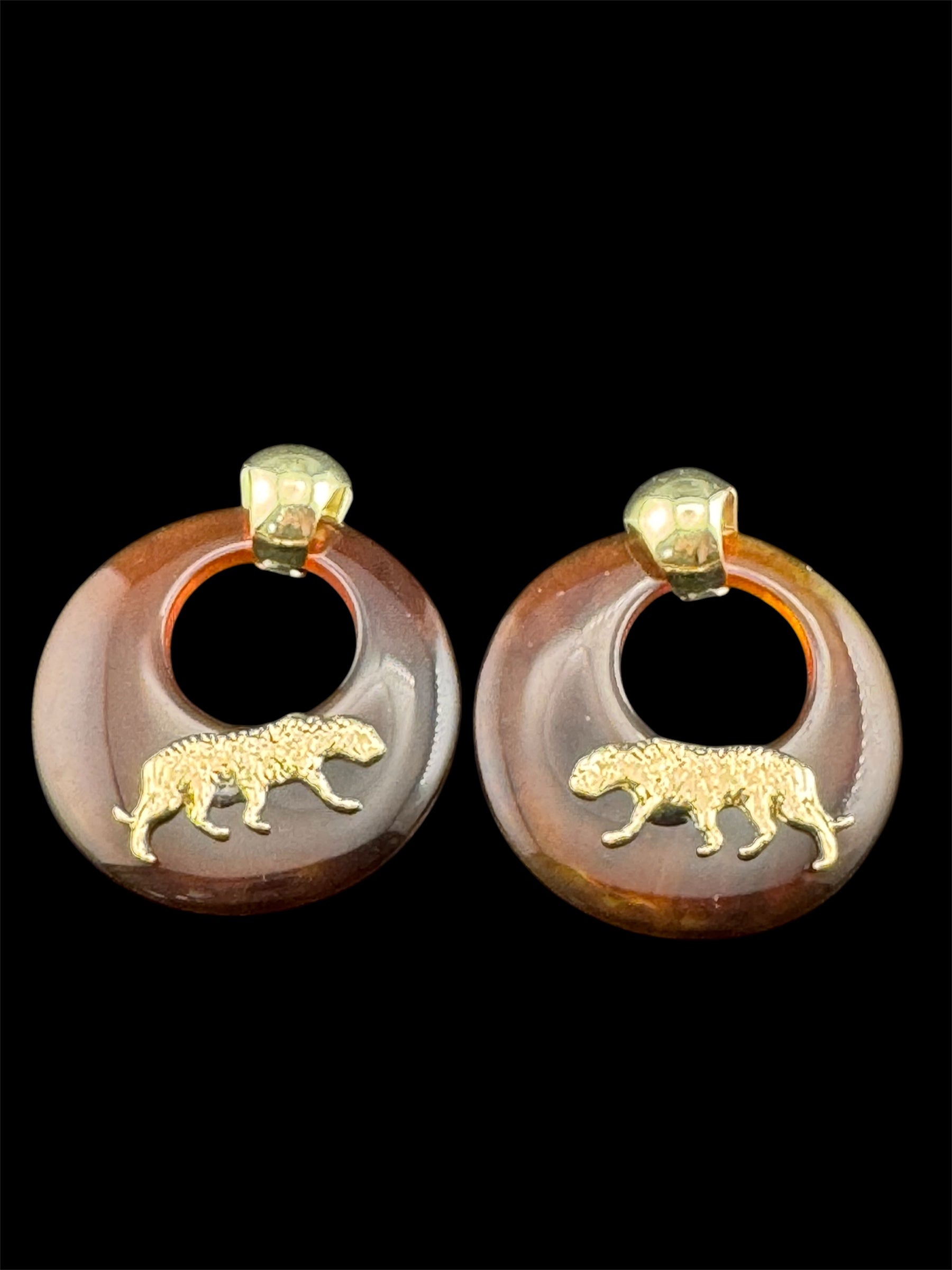 Oversized brown tortoiseshell dangly acrylic hoop earrings with gold big cat leopards , pierced ears.