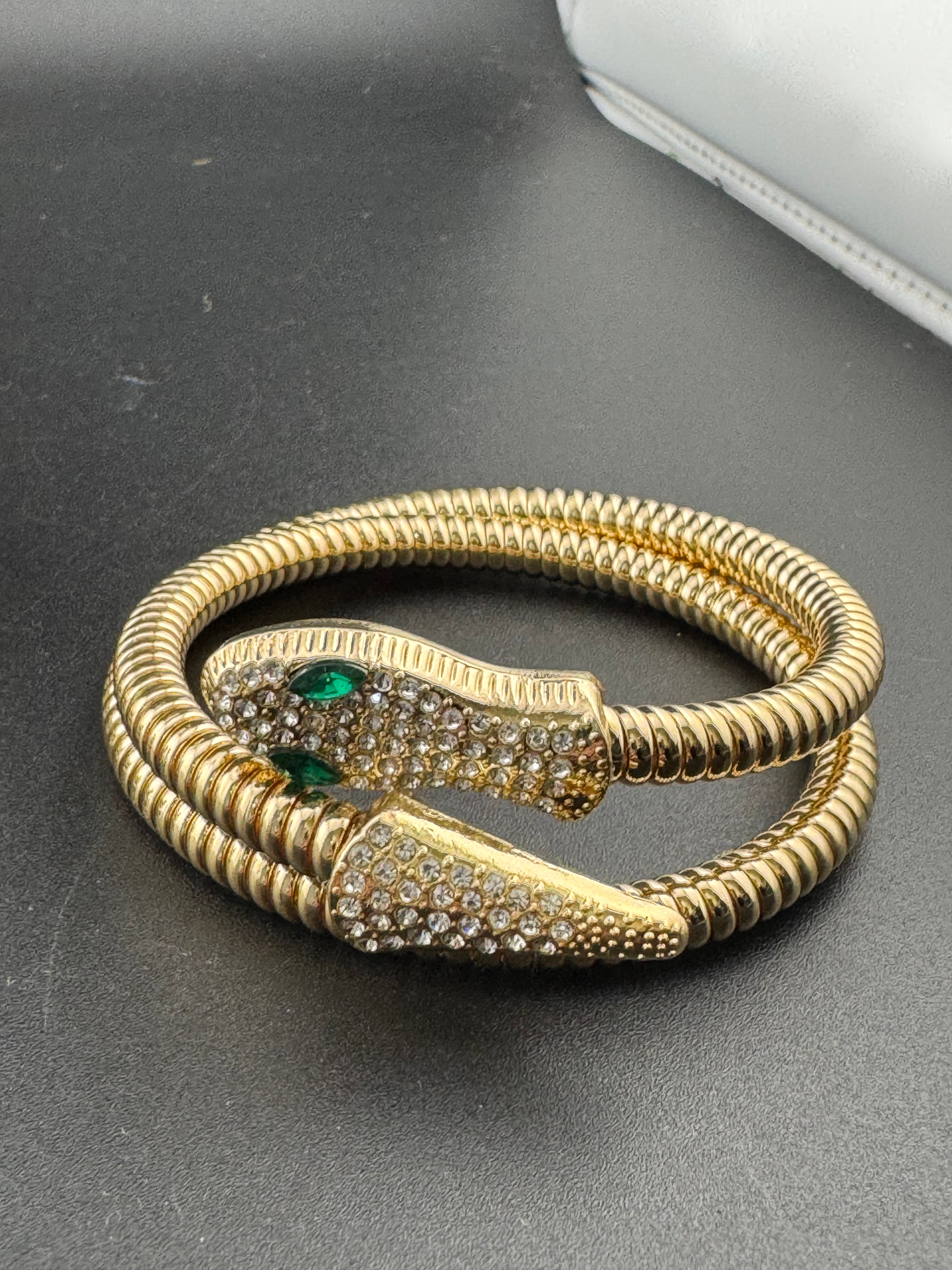 Gold crystal bendy wrap around omega snake bracelet with emerald eyes