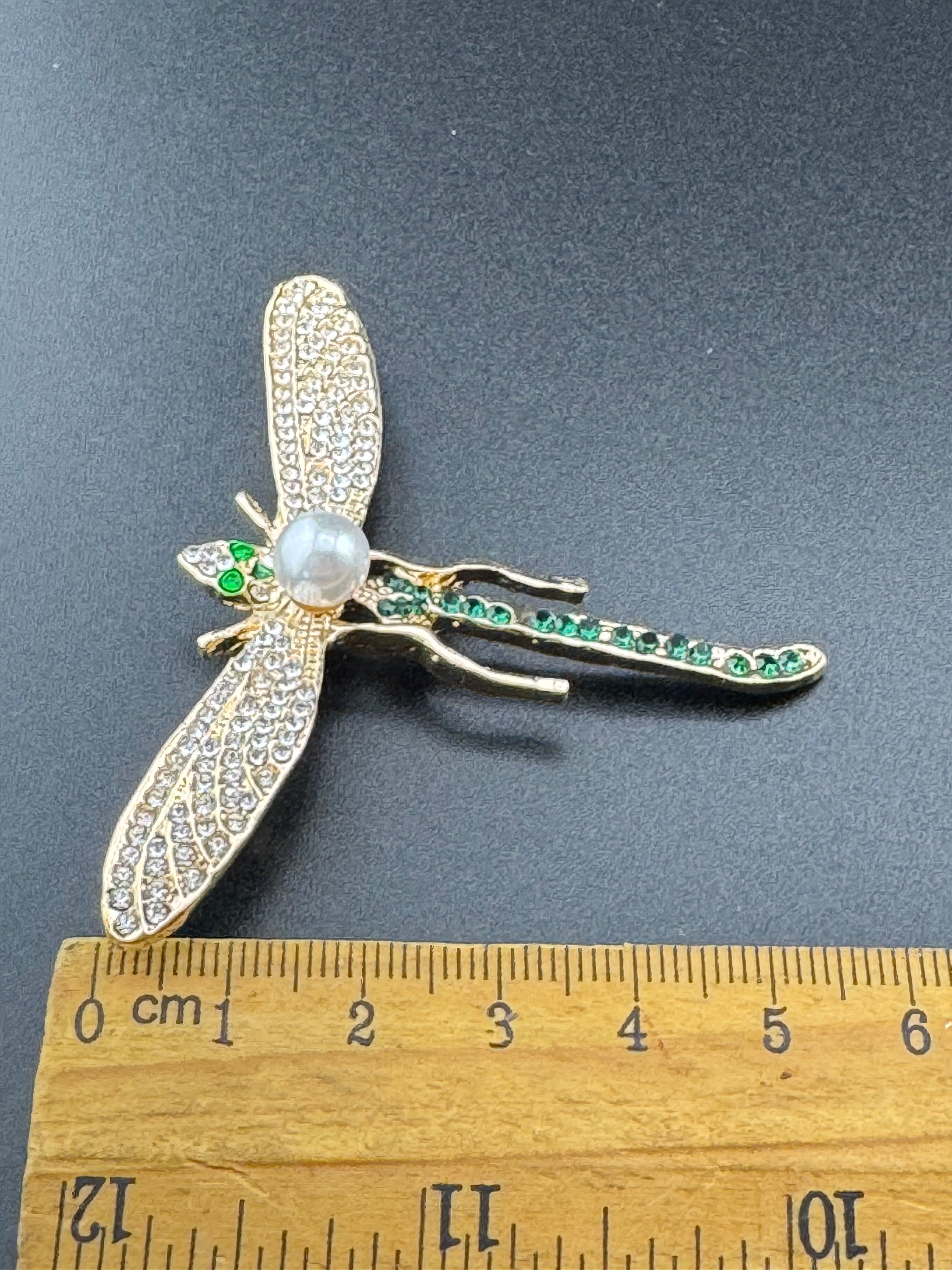 Gold dragonfly brooch set with a peal and green rhinestones
