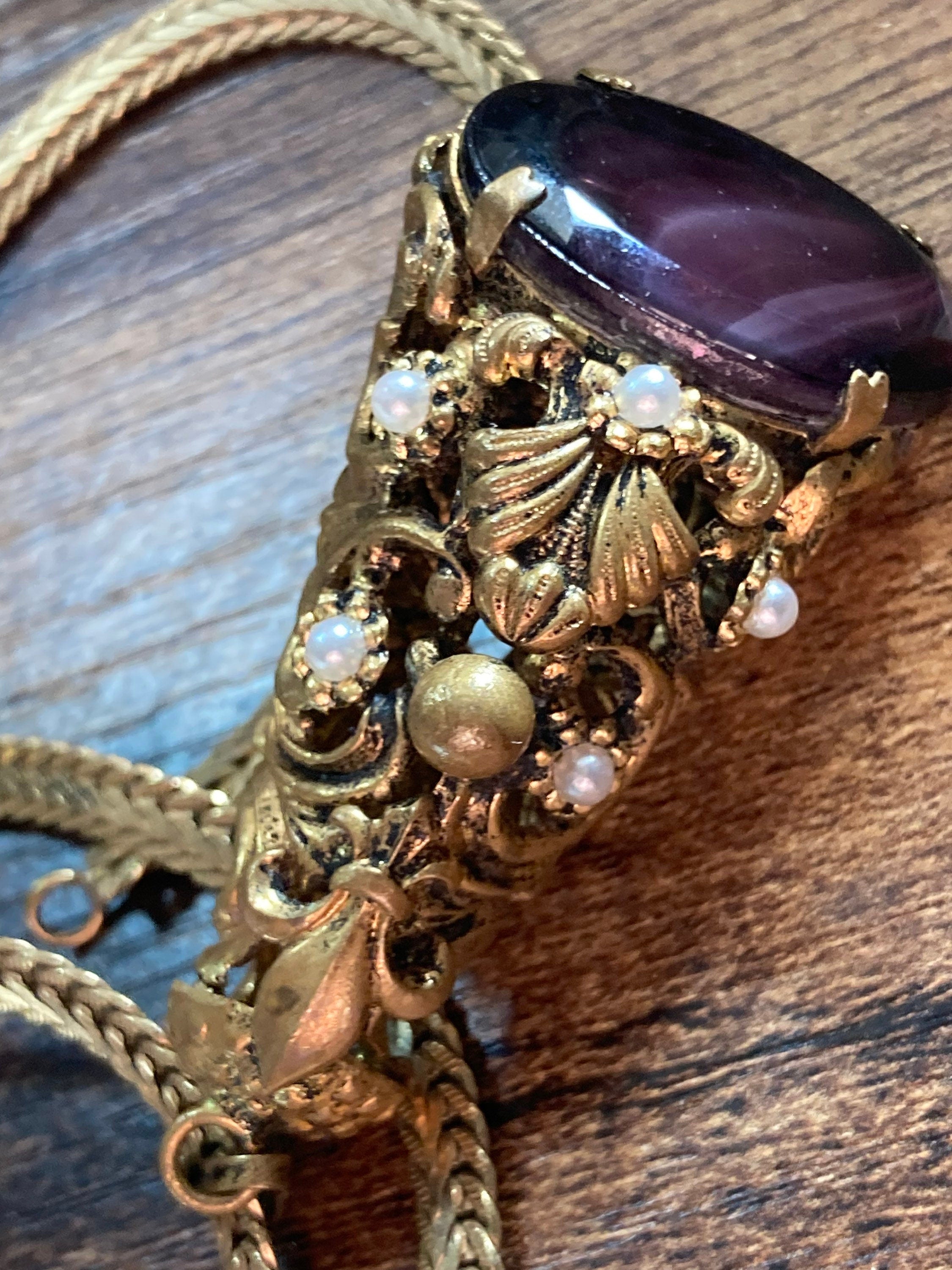 Vintage gold tone ornate gilt metal cone pendant with faux pearls and purple glass cabochon on flat chain