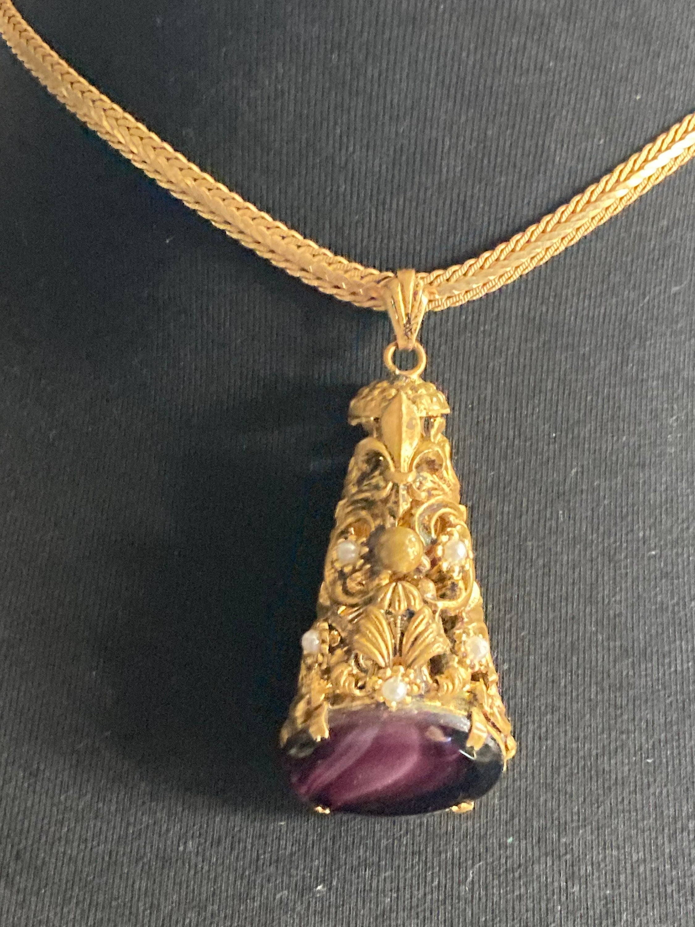 Vintage gold tone ornate gilt metal cone pendant with faux pearls and purple glass cabochon on flat chain