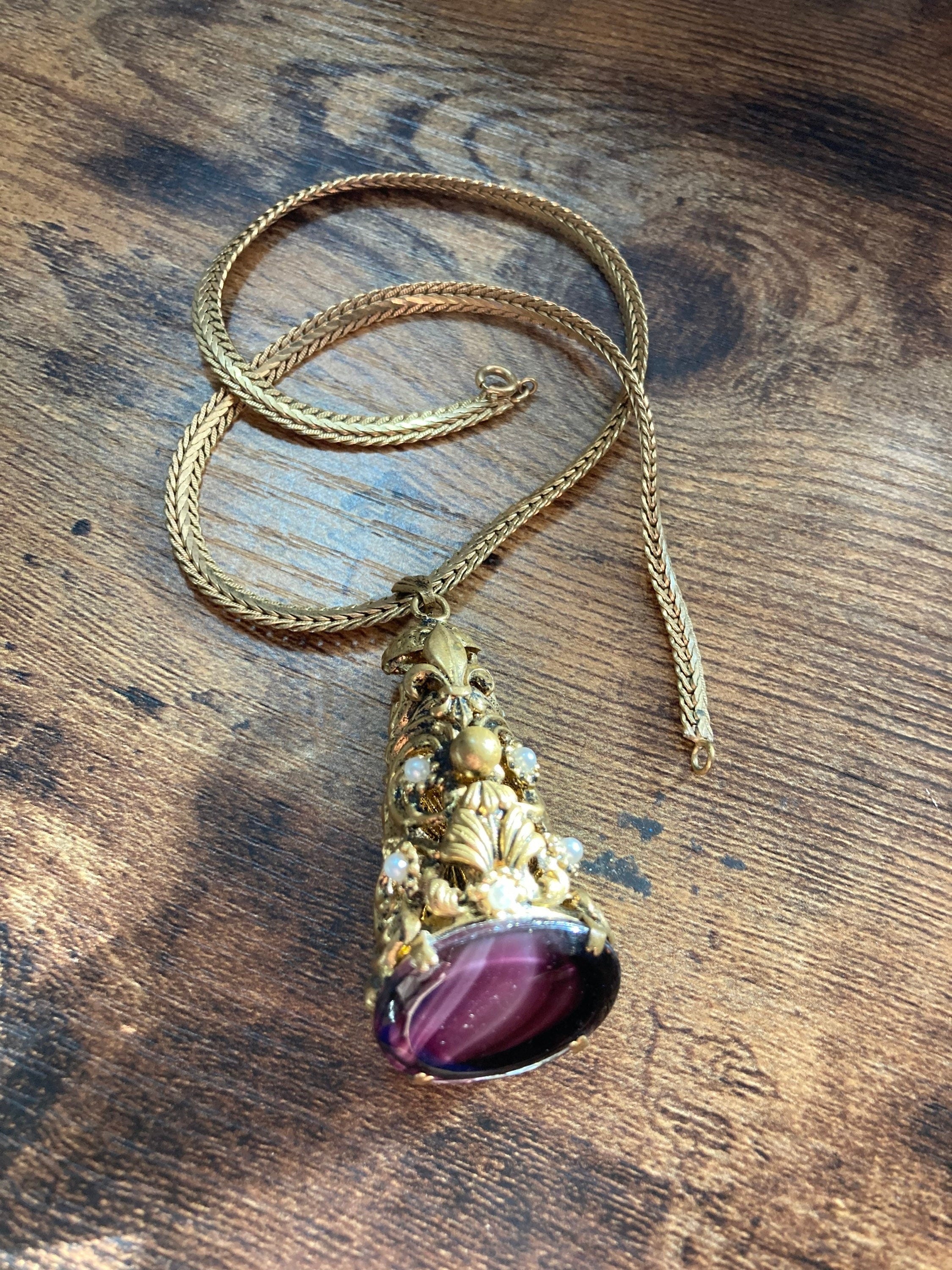 Vintage gold tone ornate gilt metal cone pendant with faux pearls and purple glass cabochon on flat chain