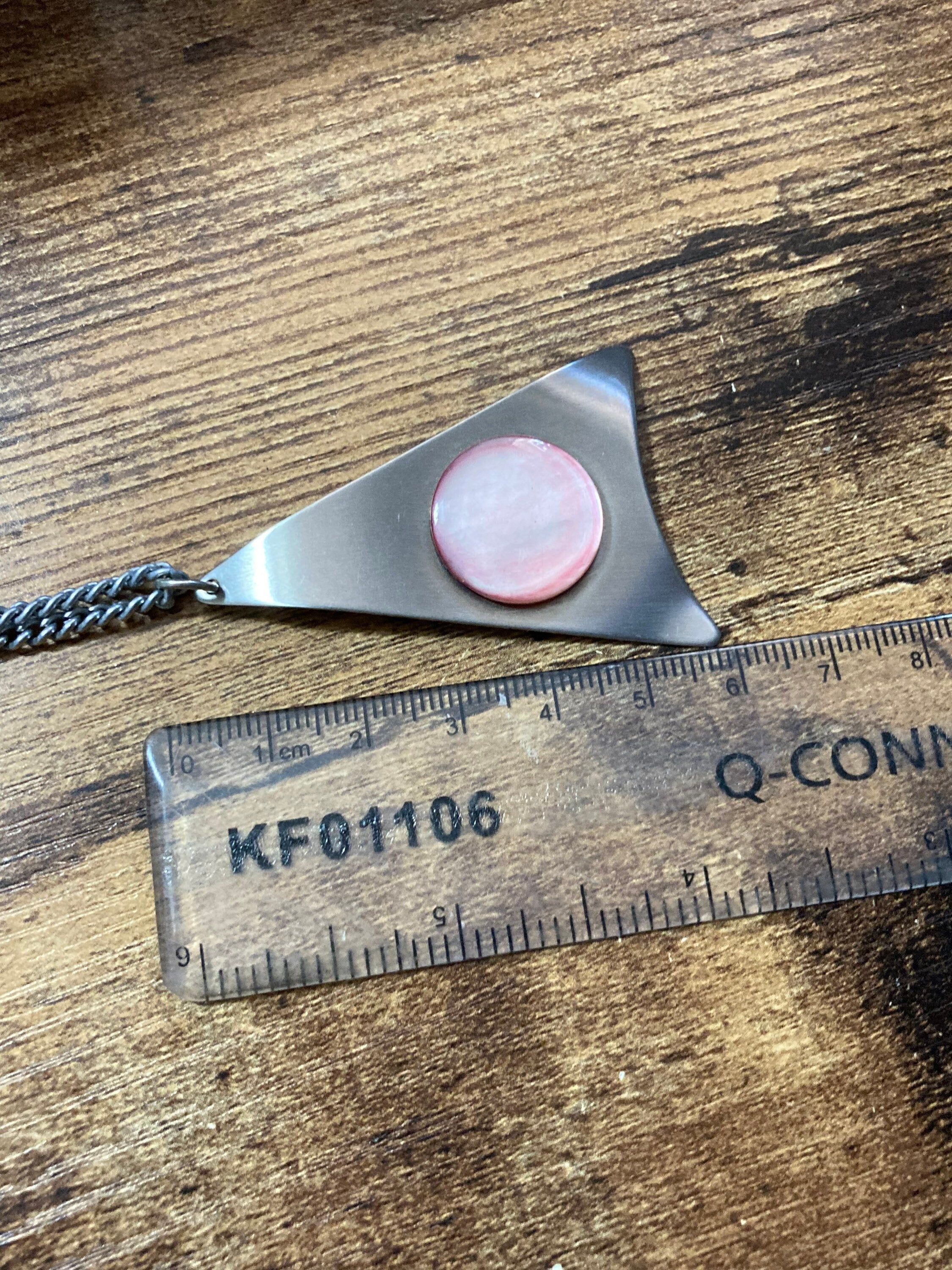 Vintage Modernist stainless steel pendant necklace with central pale pink cabochon