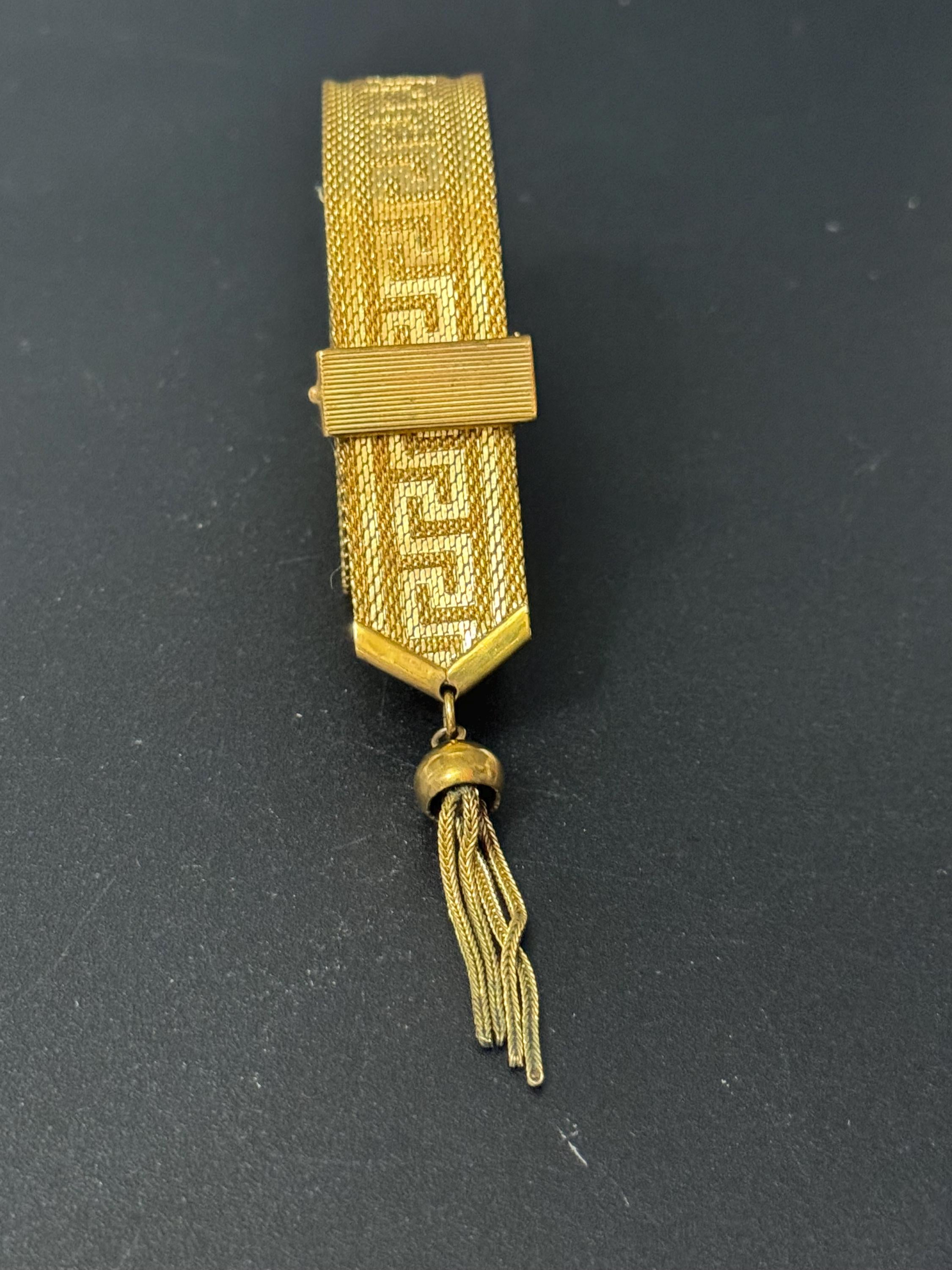 1970s Greek key design gold tone articulated flat 2cm wide tassel bracelet 19.5