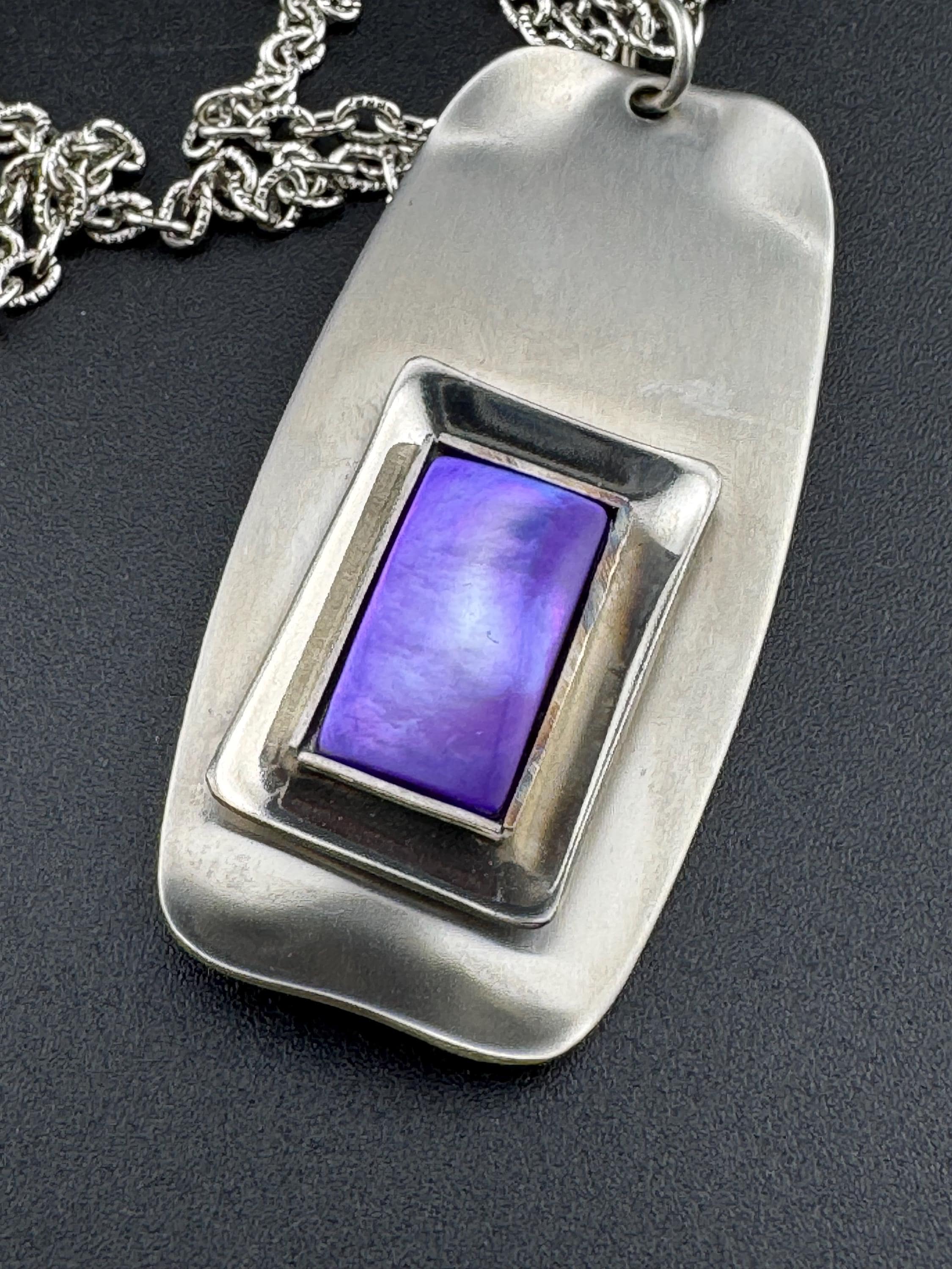 Signed Lord python Vintage Modernist silver tone stainless steel pendant necklace and chain set with central purple glass cabochon 1970s