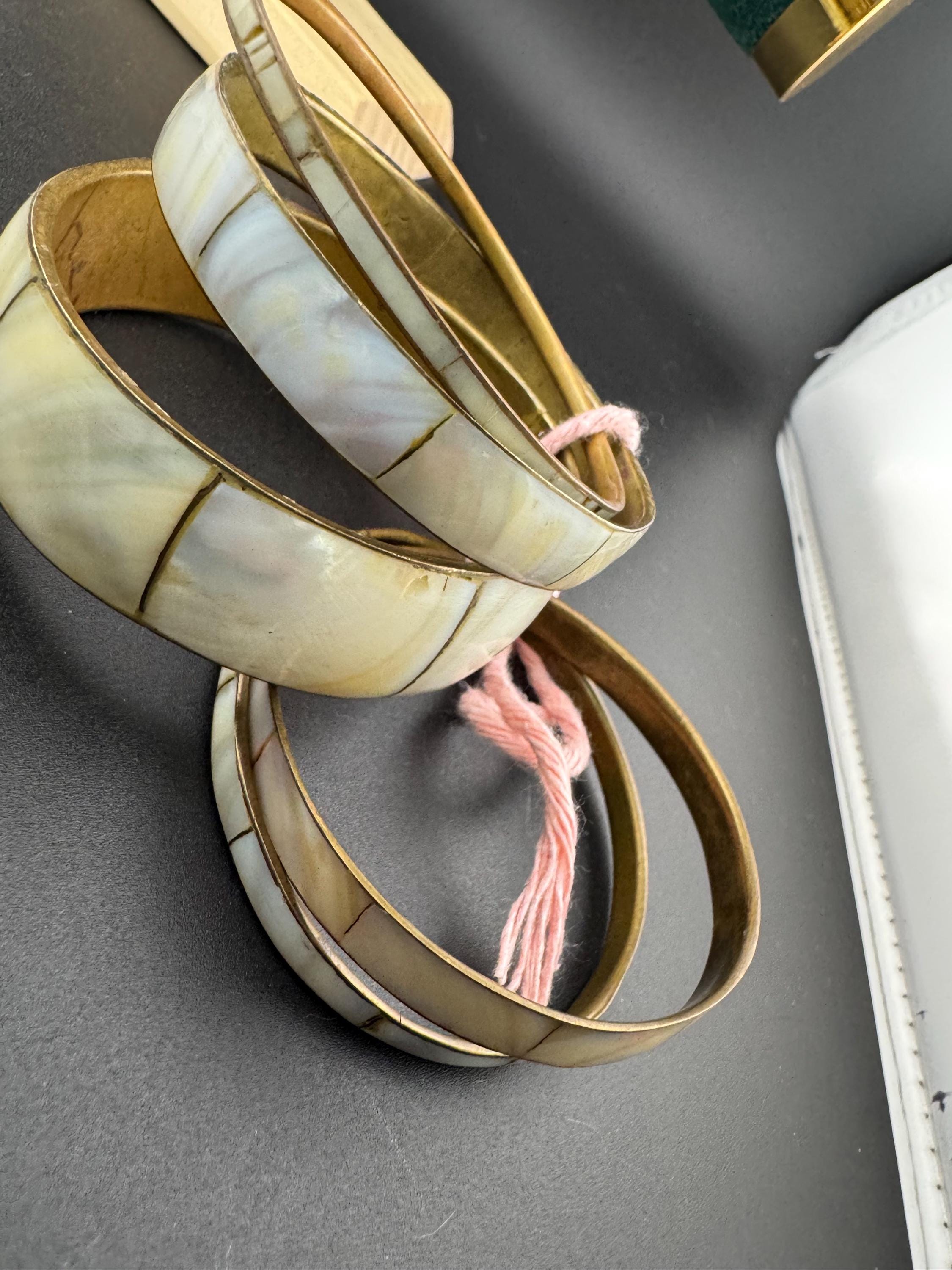 A curated set of vintage and retro gold tones mother of pearl stacking bangles, boho festival bracelets
