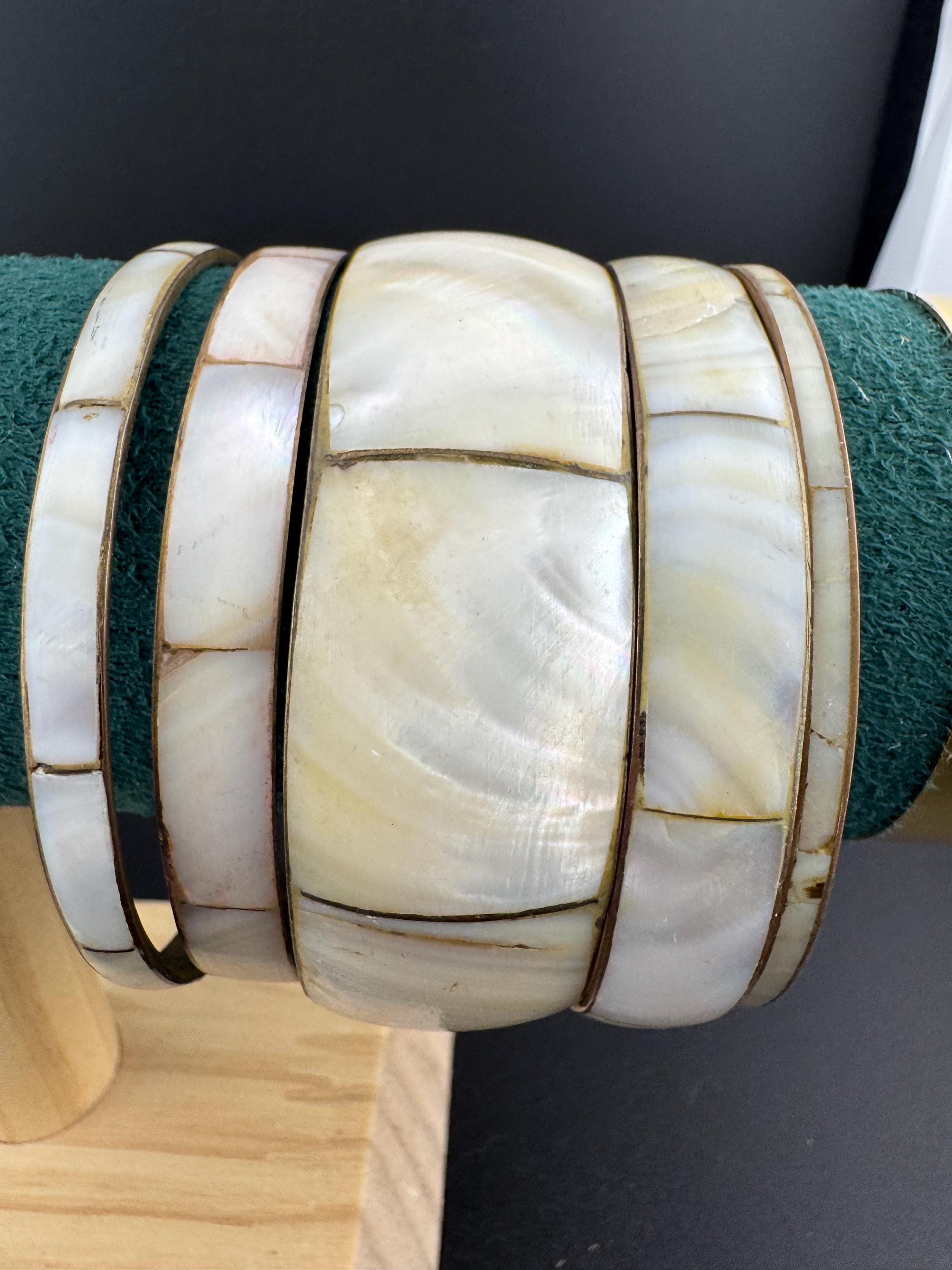 A curated set of vintage and retro gold tones mother of pearl stacking bangles, boho festival bracelets
