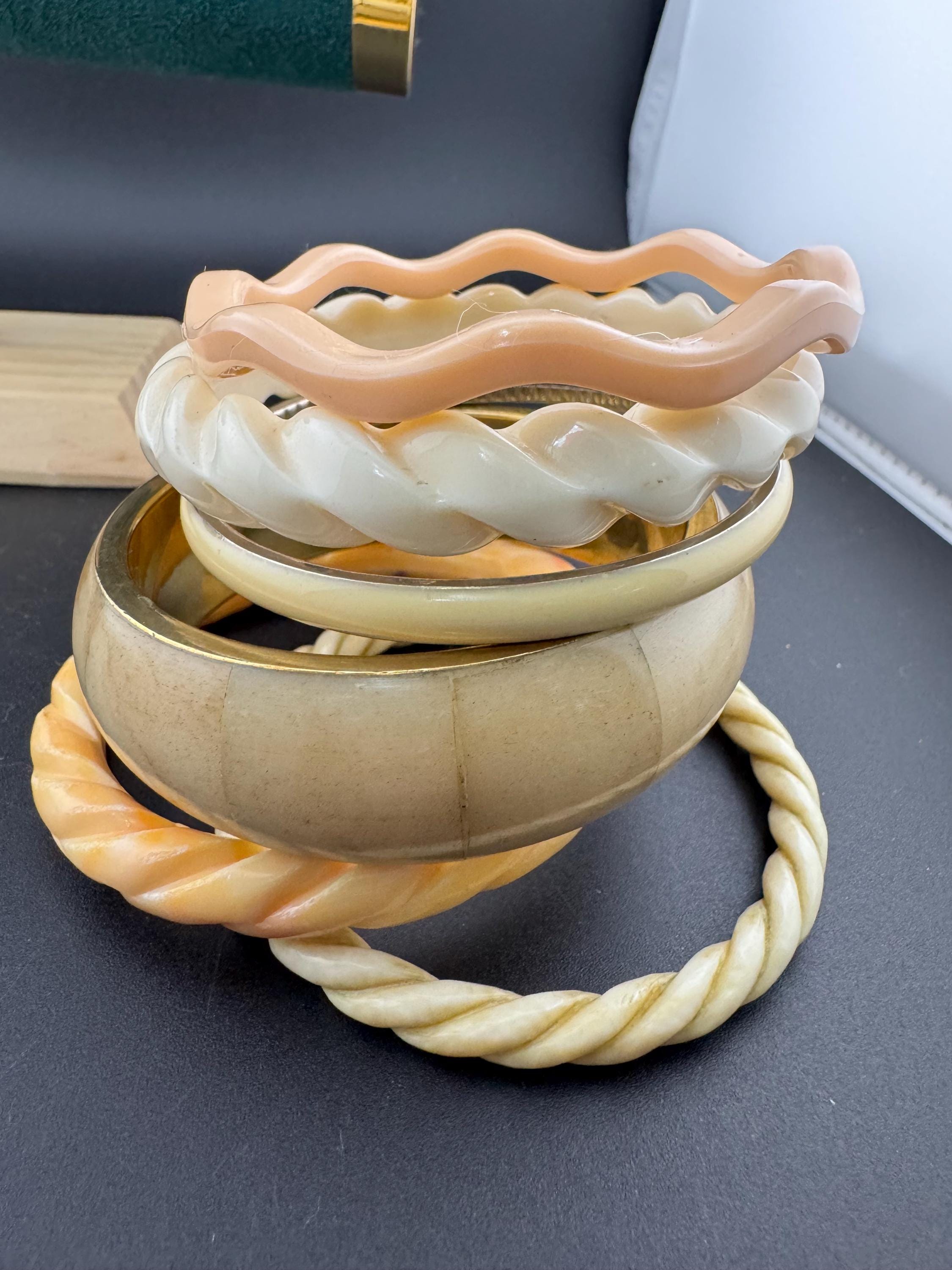 A curated stack of Cream pink beige neutrals vintage and retro plastic bangles