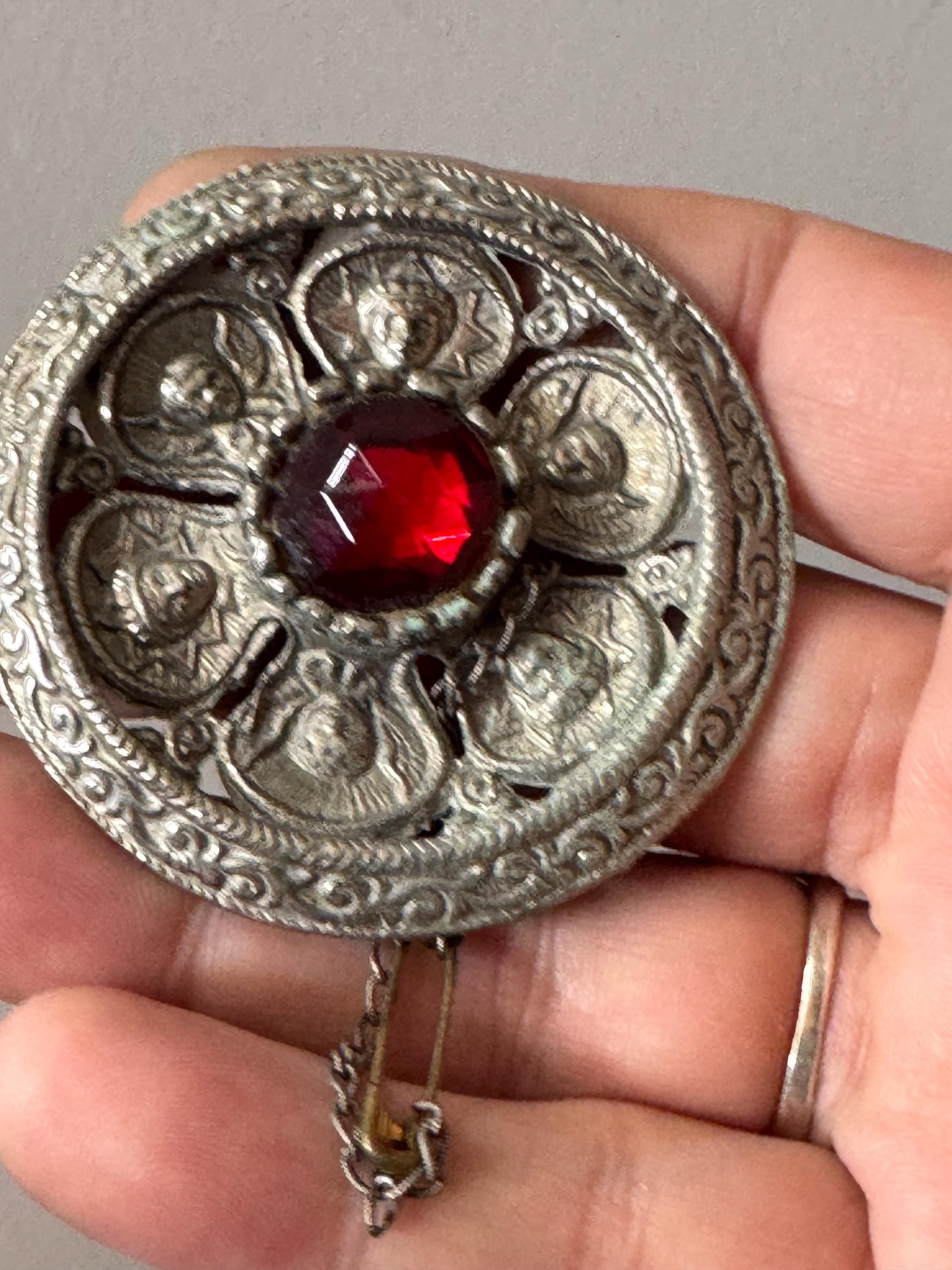 vintage round silver tone Etruscan figural faces large medallion shield brooch set with ruby faceted cabochon