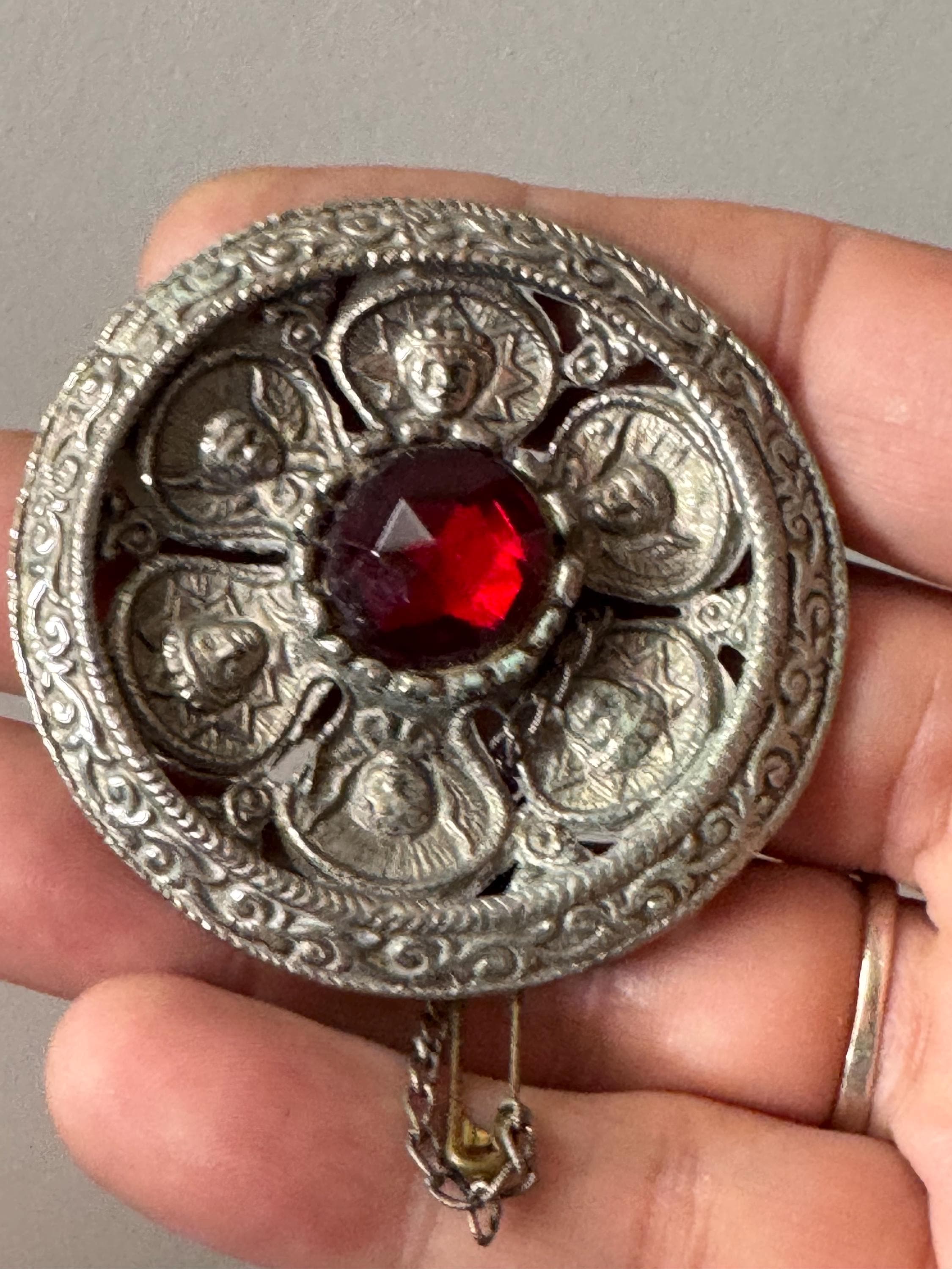 vintage round silver tone Etruscan figural faces large medallion shield brooch set with ruby faceted cabochon