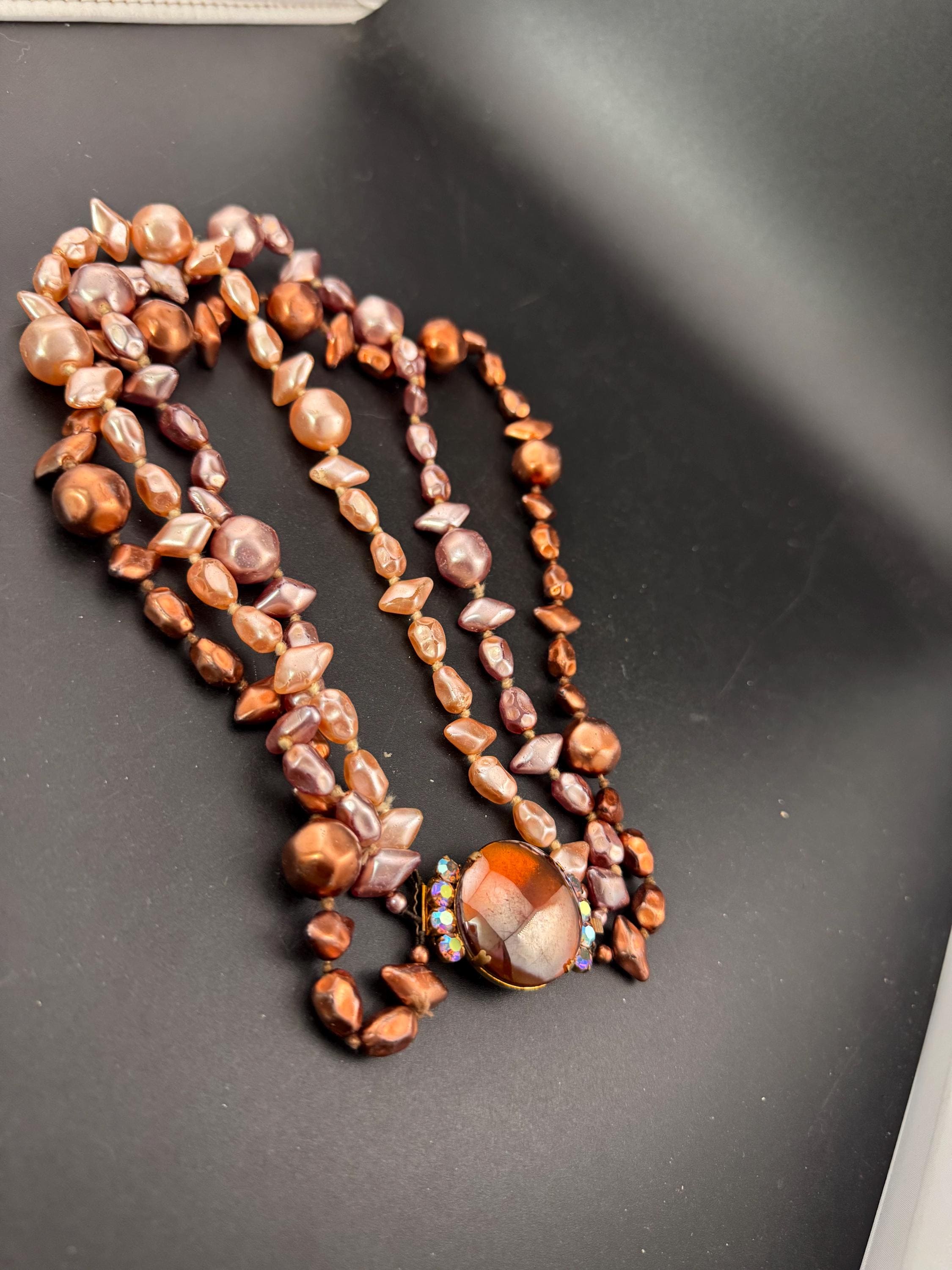 Fantastic Vintage triple strand row brown pink bronze glass faux pearl beaded multistrand necklace with a huge glass cabochon clasp