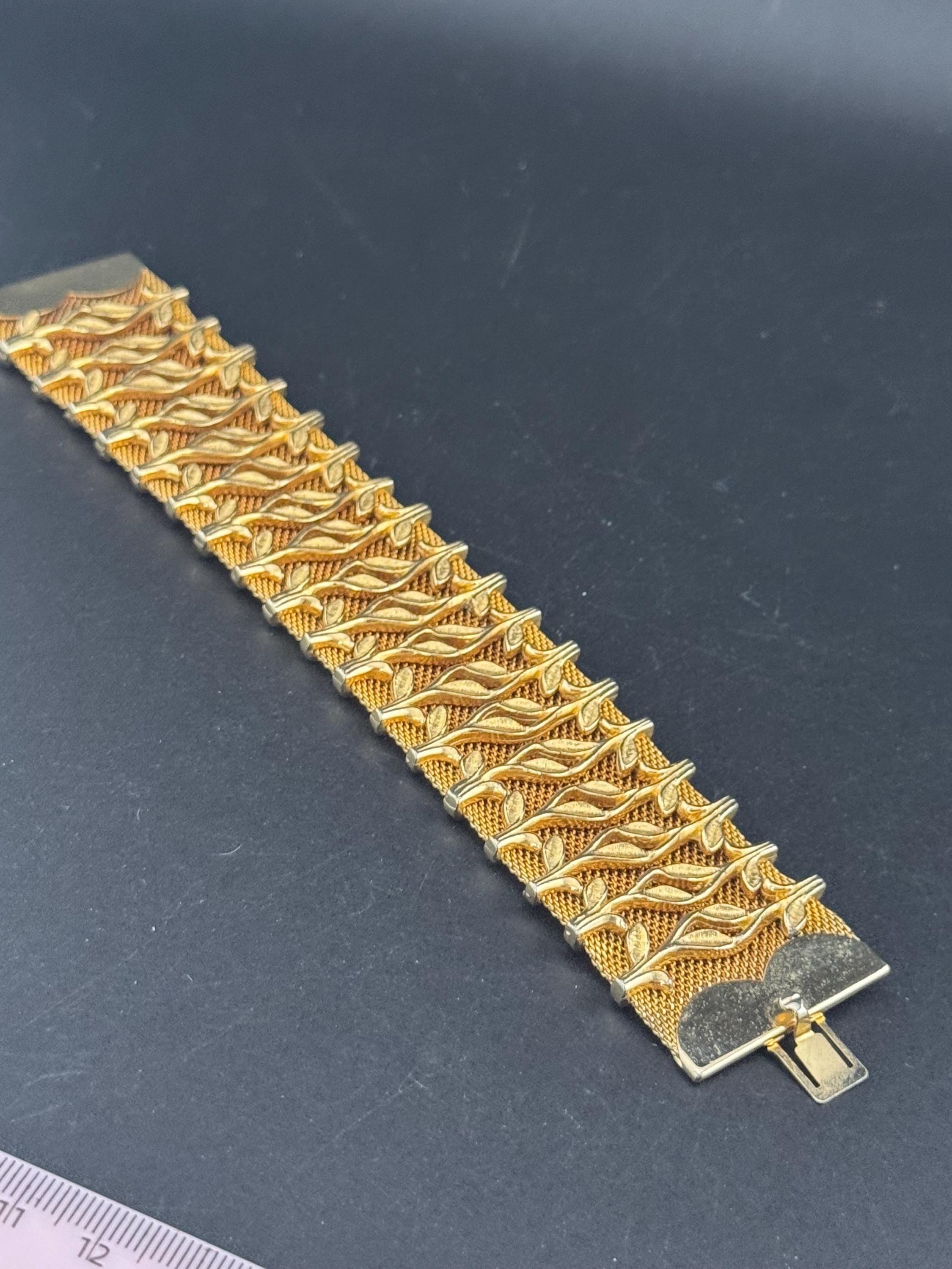 Vintage gold tone 3.5cm wide woven flat articulated Mesh bracelet 18.5cm long with floral detail