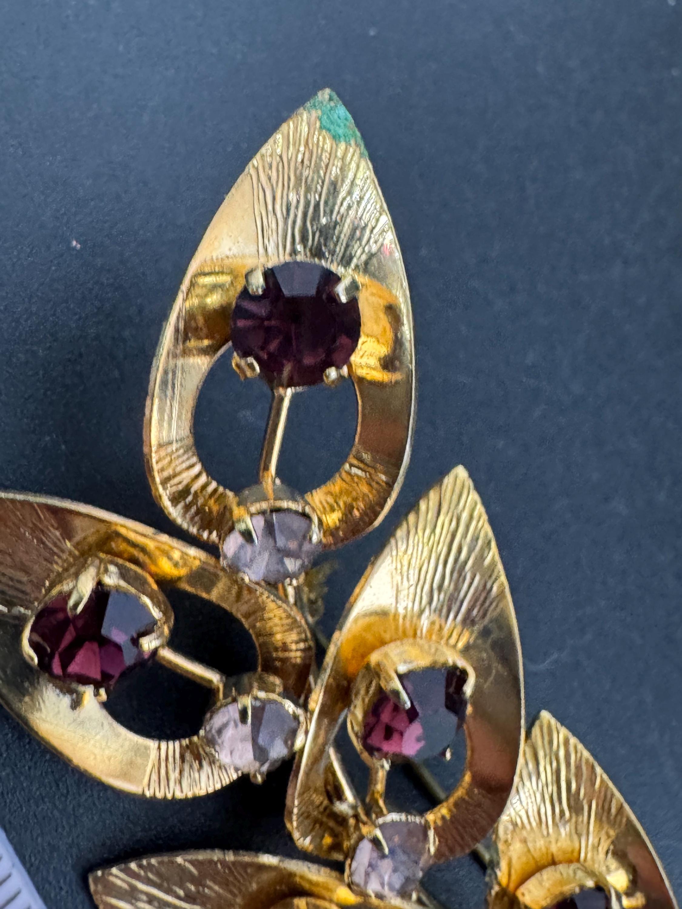 Vintage dark amethyst purple glass rhinestone gold plated floral brooch , mid century