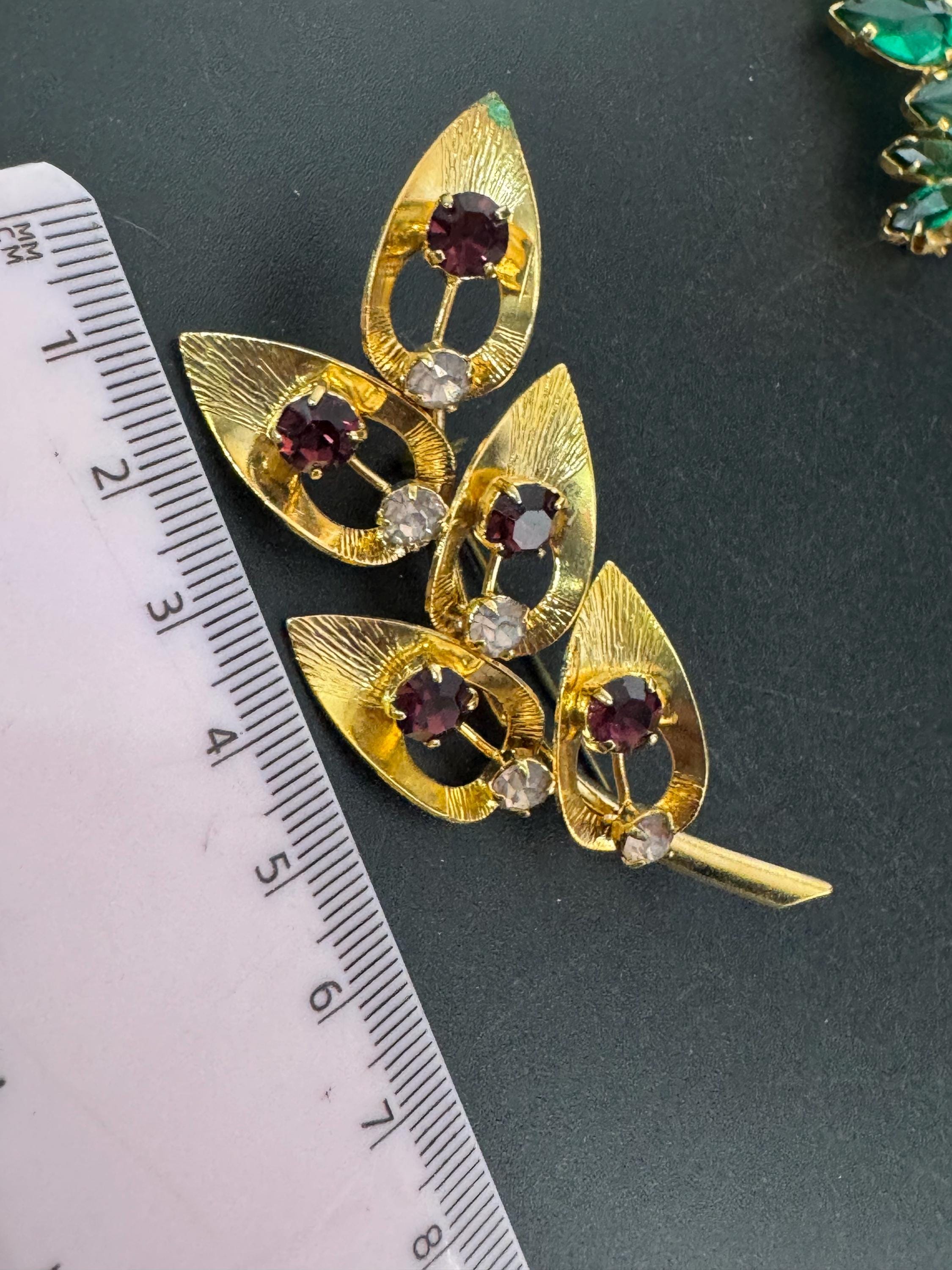 Vintage dark amethyst purple glass rhinestone gold plated floral brooch , mid century