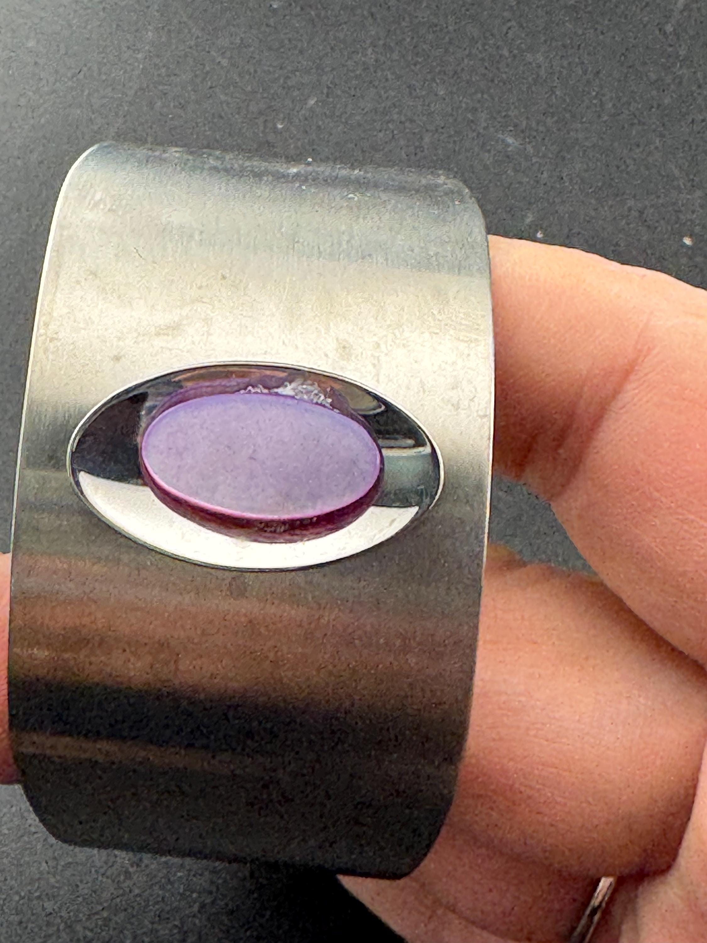 1970s stainless steel bangle, set with purple shell cabochon