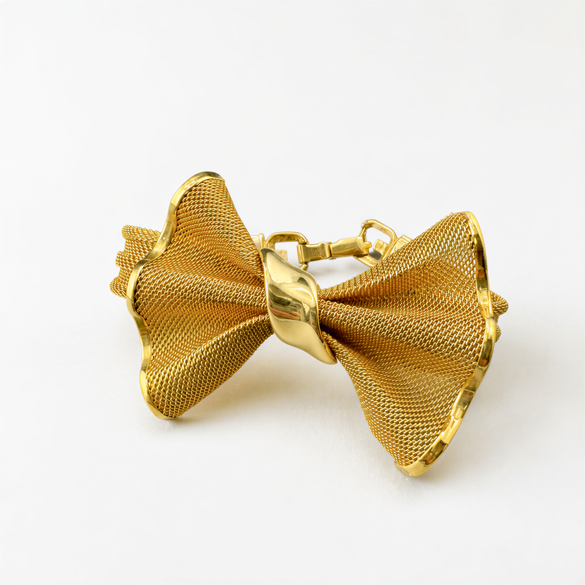 A gold-colored bow tie with a metallic, scalloped edge is displayed against a white background.