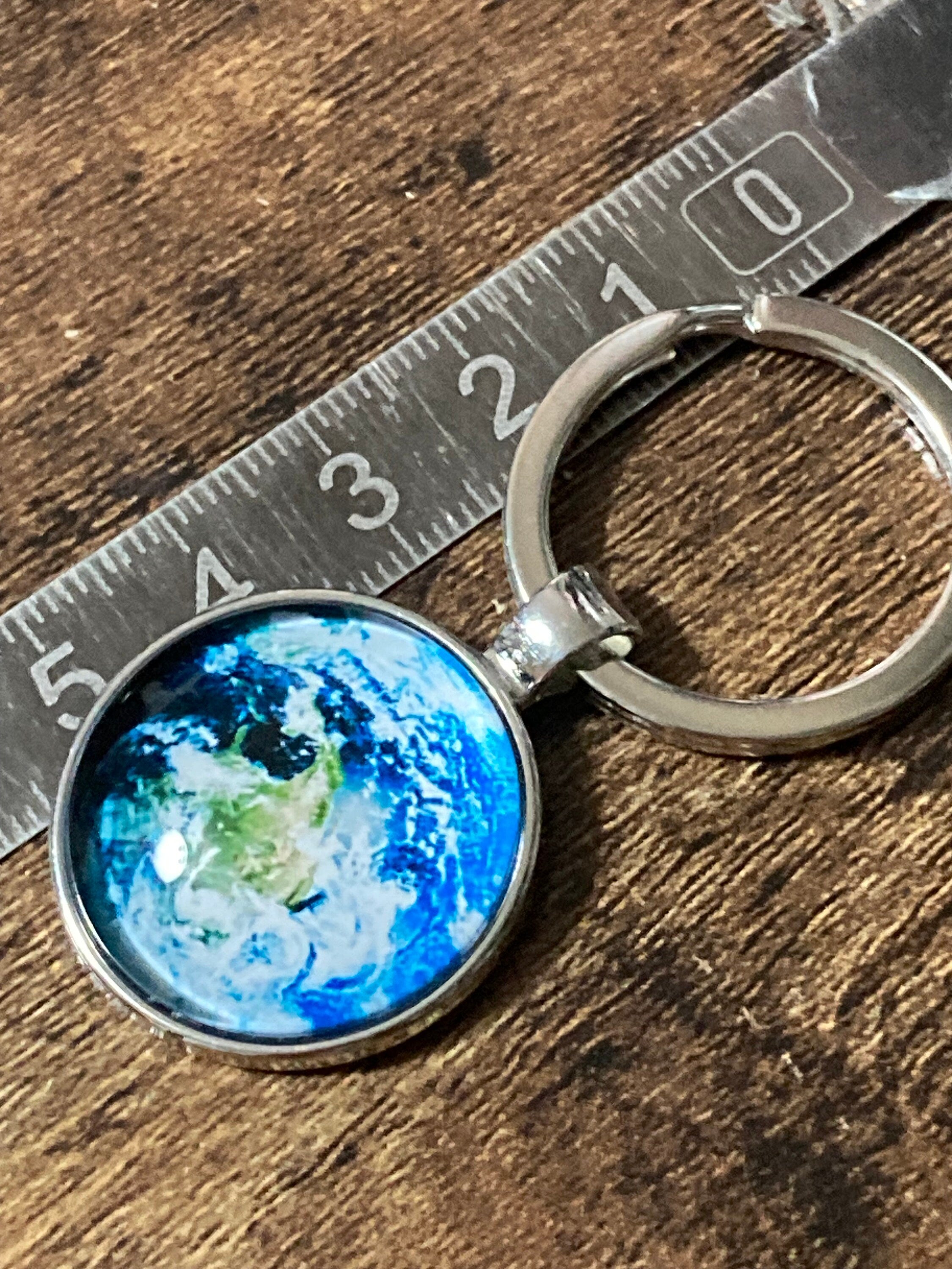 Aerial view of earth globe world silver tone keyring glass cabochon
