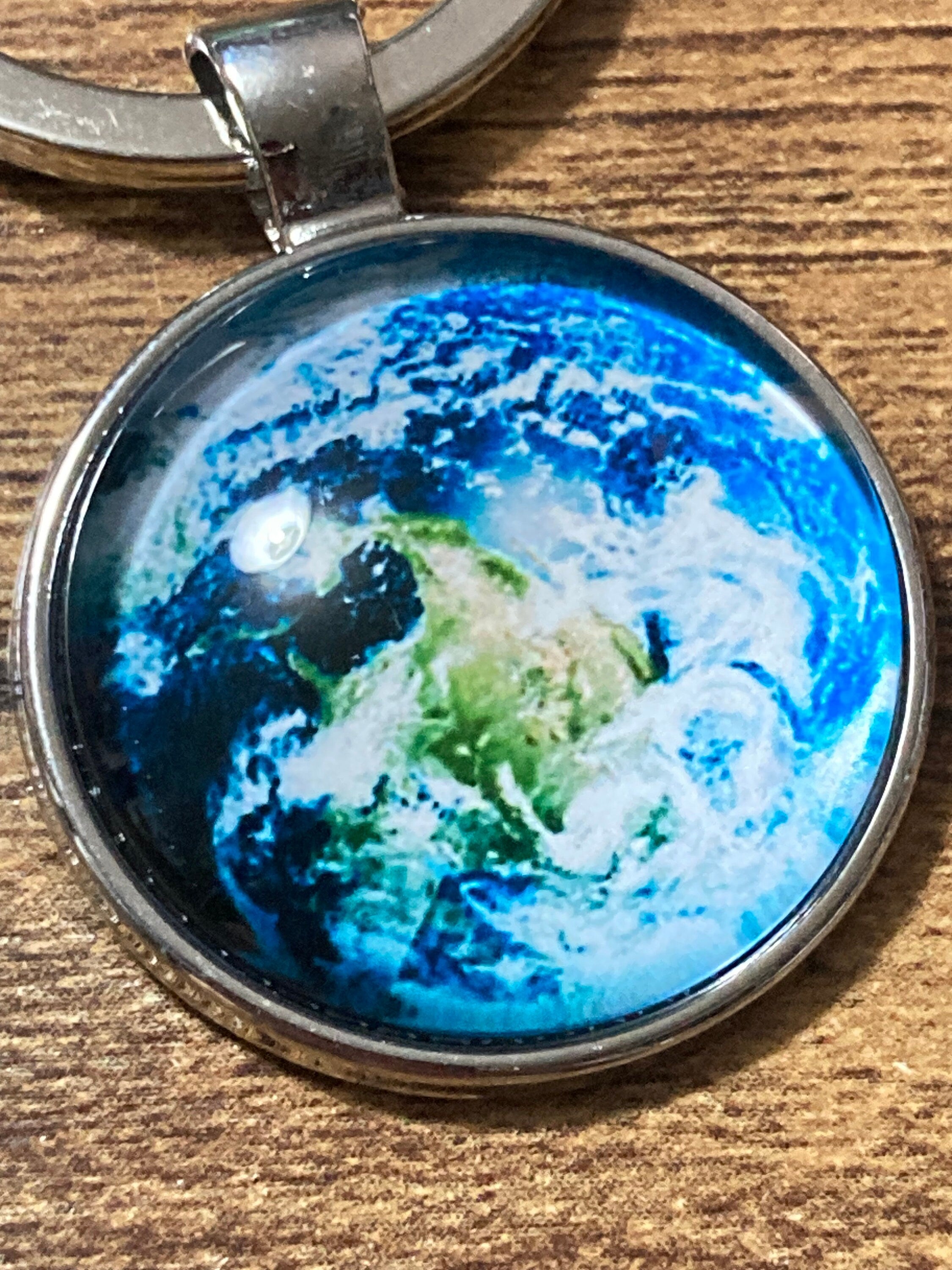 Aerial view of earth globe world silver tone keyring glass cabochon