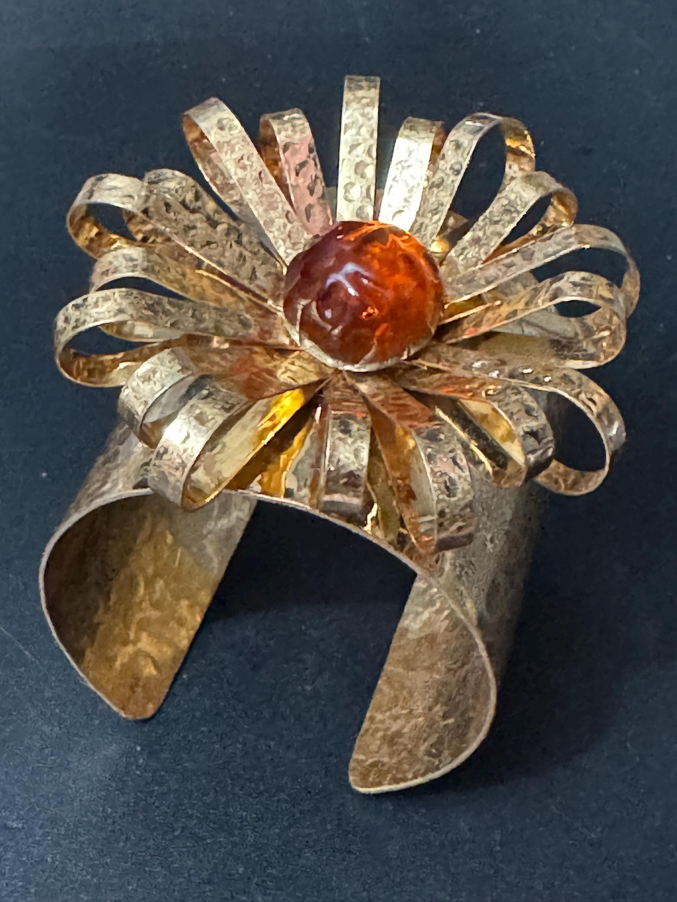 oversized vintage modernist style gold tone wide bangle with a huge flower and central orange cabochon