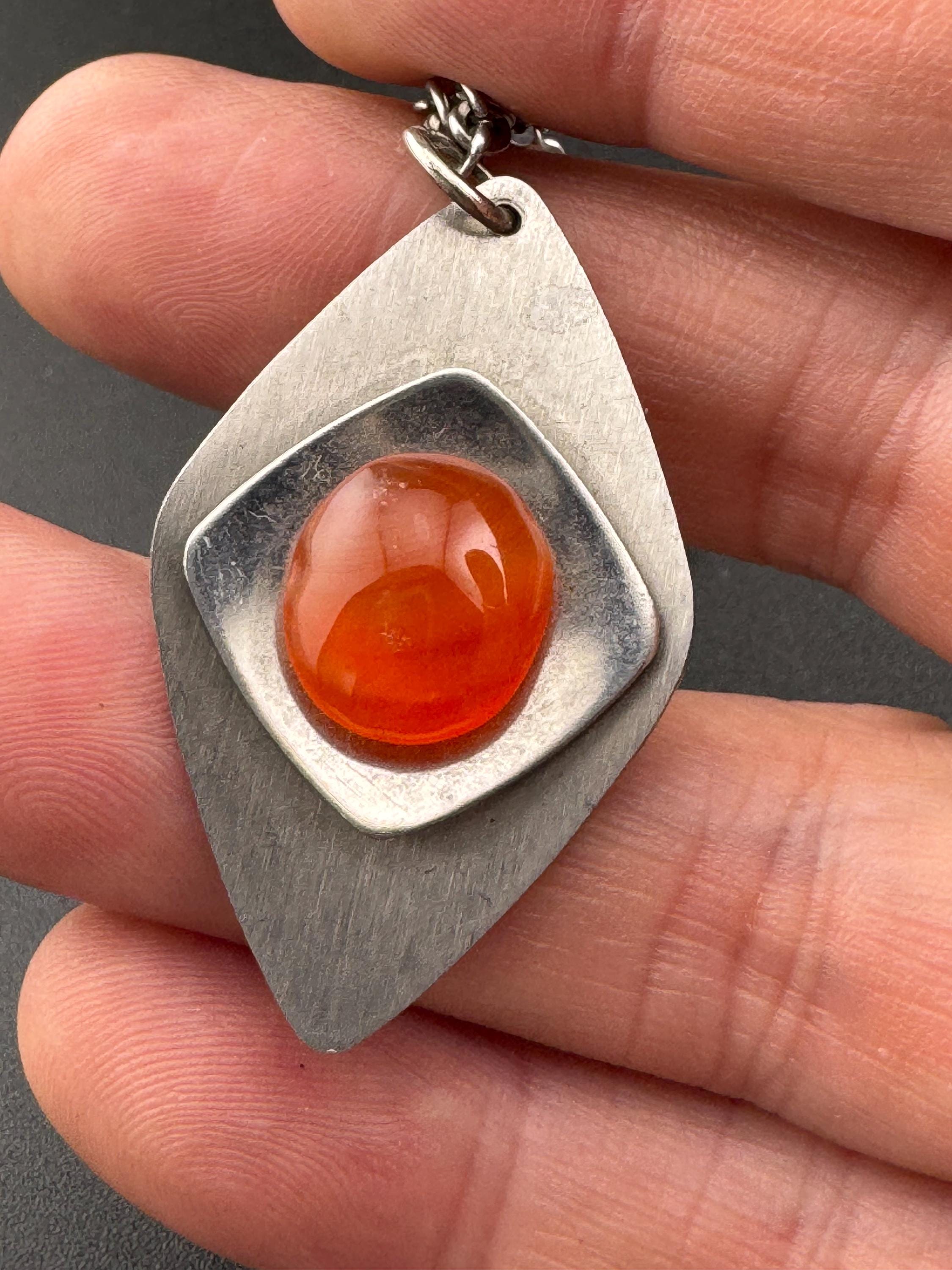 Vintage Modernist silver tone stainless steel pendant necklace and chain set with central orange glass cabochon 1970s