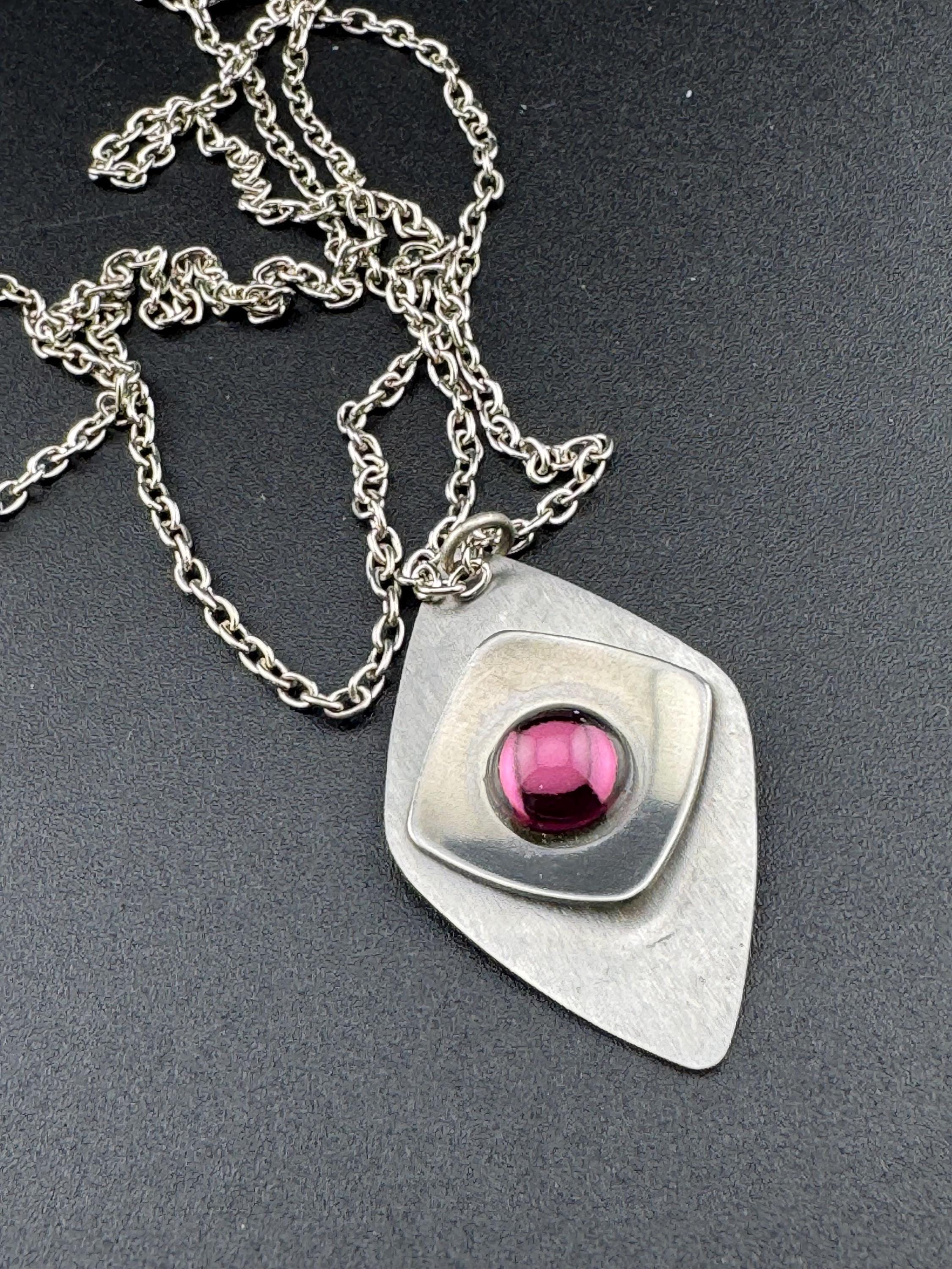 Vintage Modernist silver tone stainless steel pendant necklace and chain set with central purple glass cabochon 1970s