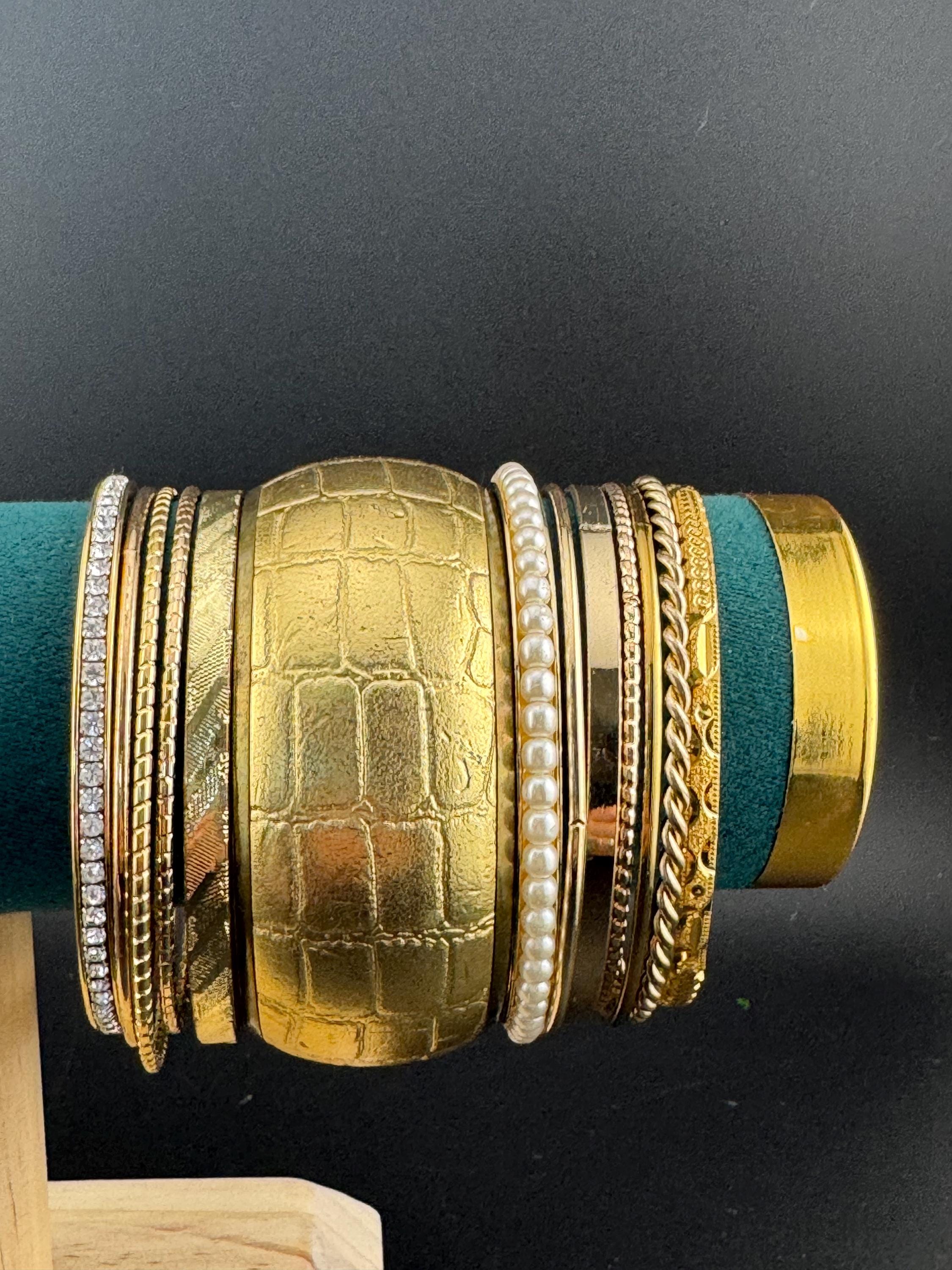 A curated set of vintage and retro gold tones stacking bangles,  boho festival bracelets