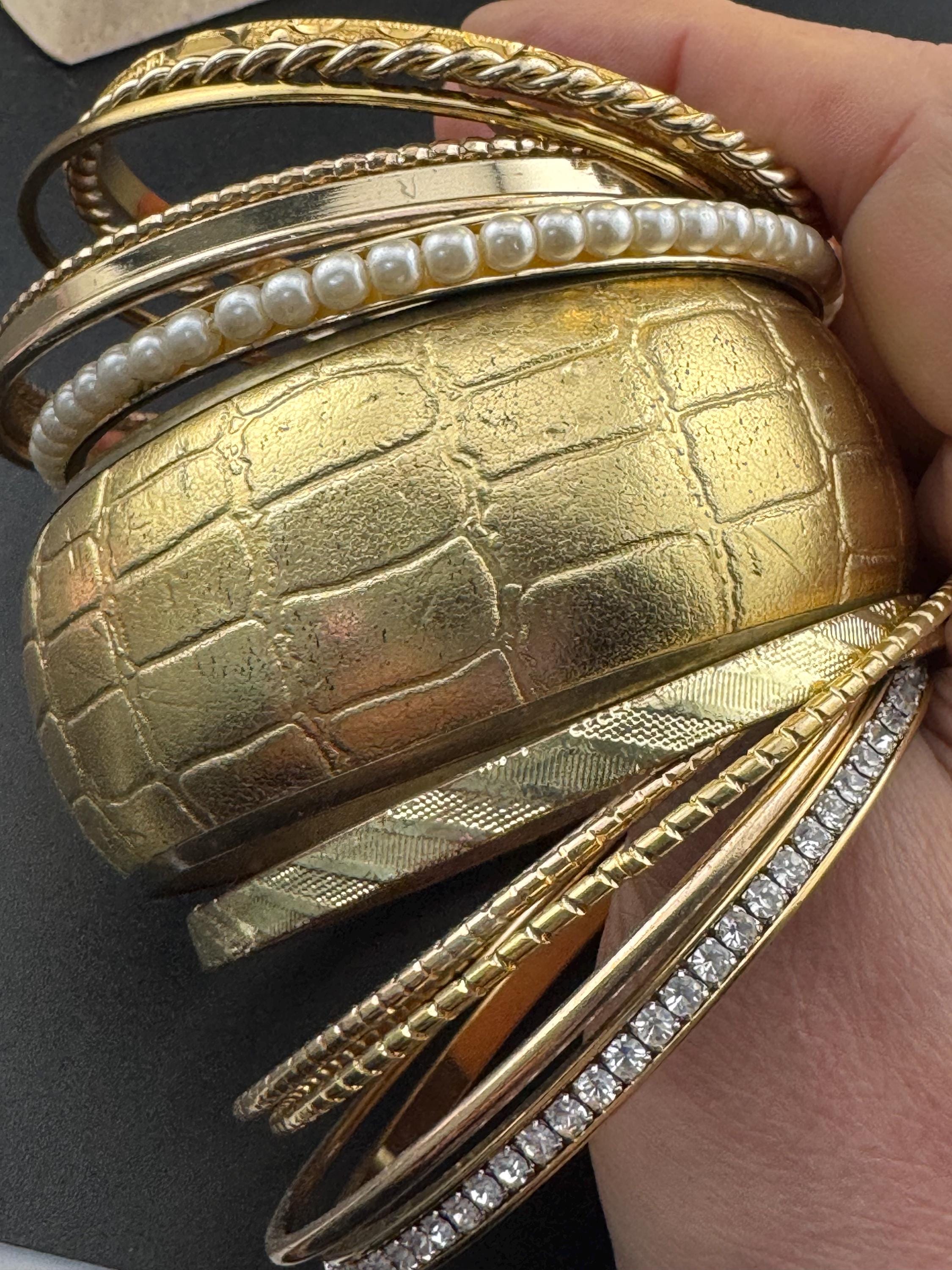 A curated set of vintage and retro gold tones stacking bangles,  boho festival bracelets