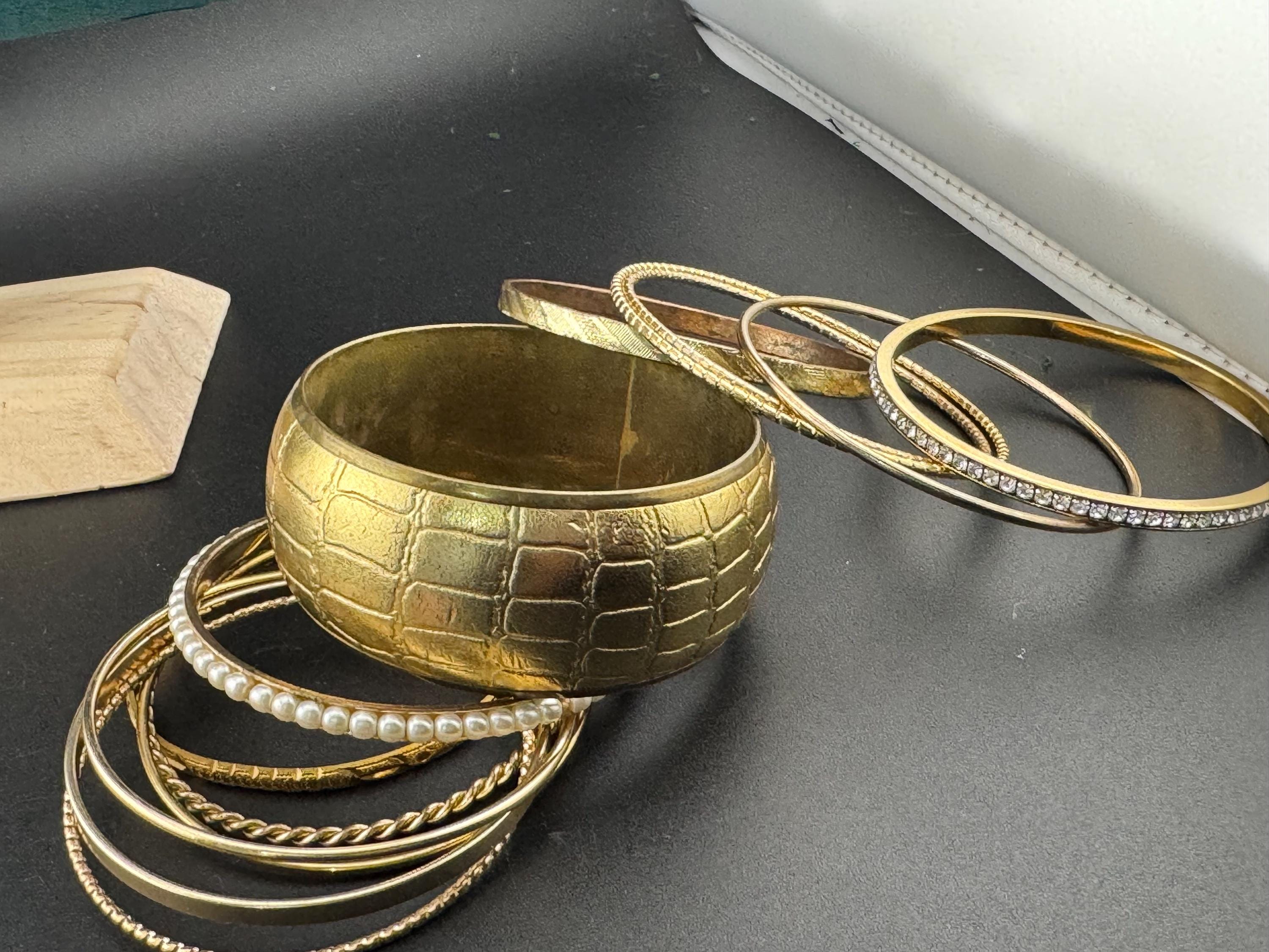 A curated set of vintage and retro gold tones stacking bangles,  boho festival bracelets