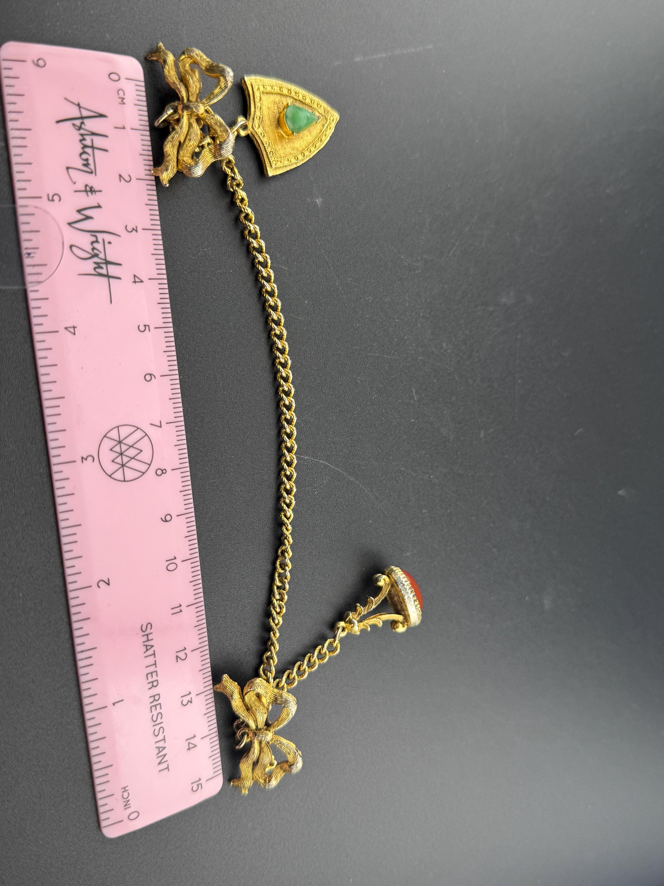 vintage double brooch gold tone with green gem set shield and faux carnelian cabochon jumper guards cloak clips