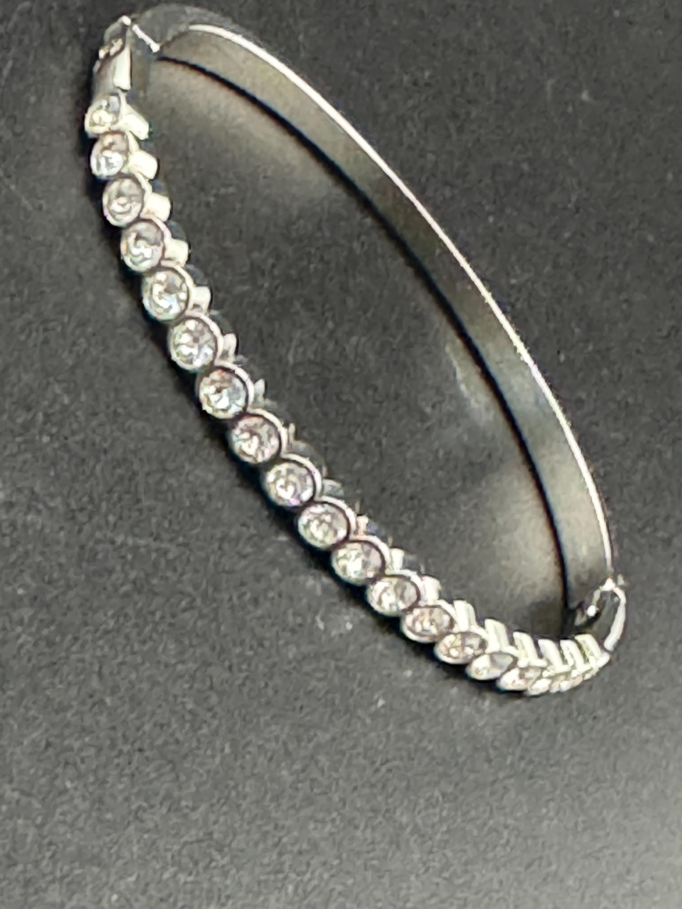 Vintage slim silver tone hinged bangle bracelet with clear glass bezel set rhinestones crystals, signed