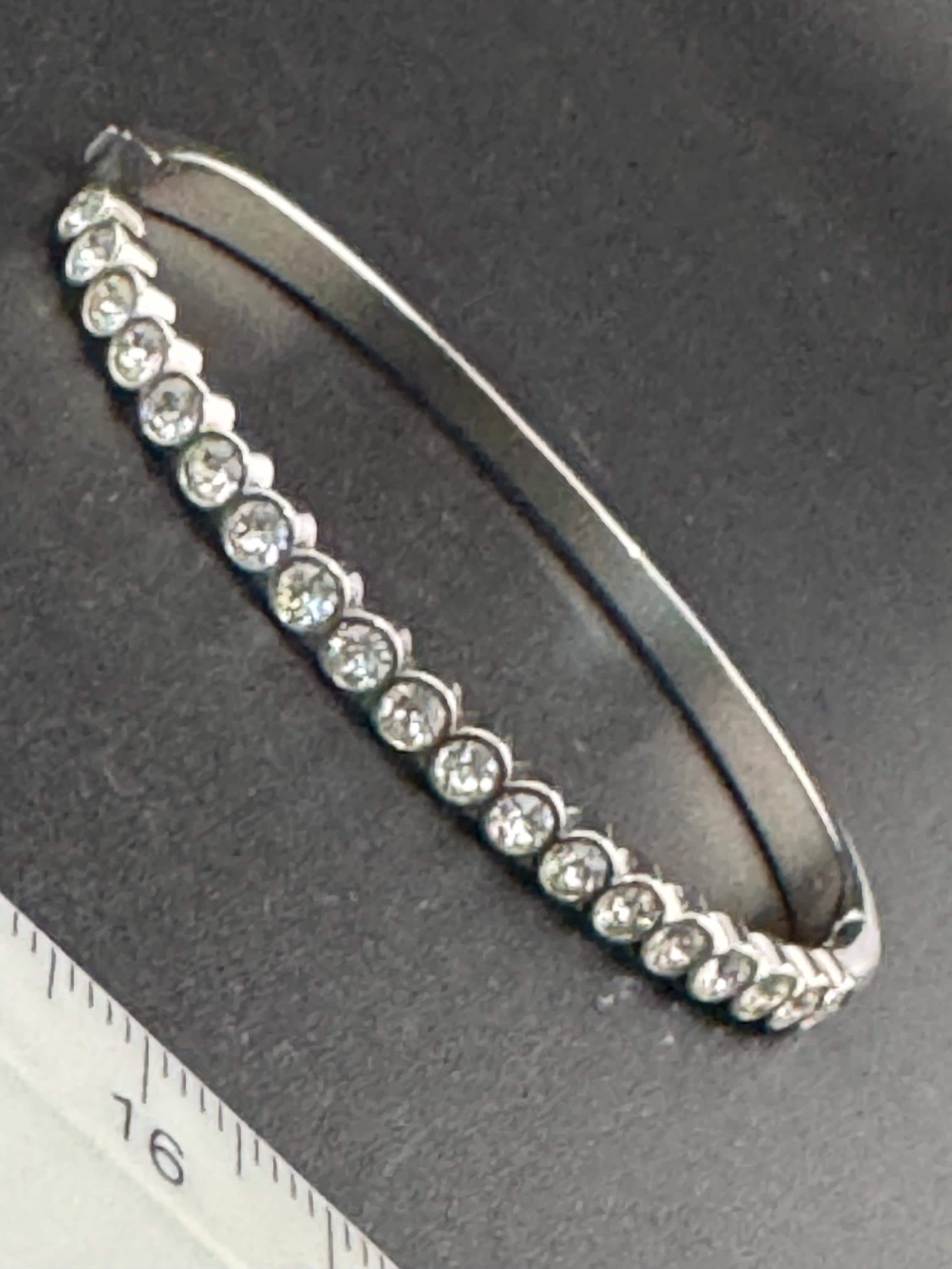 Vintage slim silver tone hinged bangle bracelet with clear glass bezel set rhinestones crystals, signed