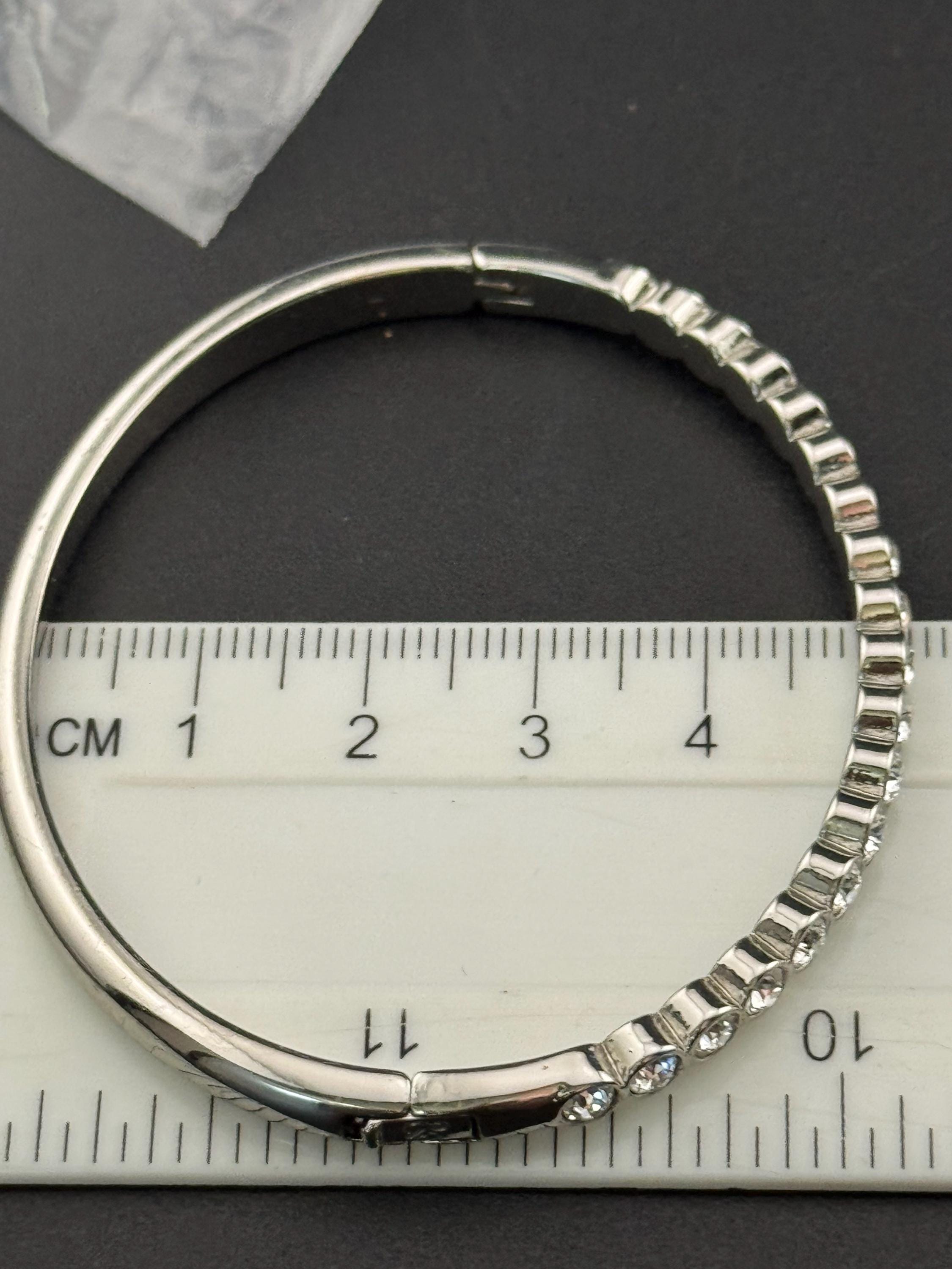 Vintage slim silver tone hinged bangle bracelet with clear glass bezel set rhinestones crystals, signed