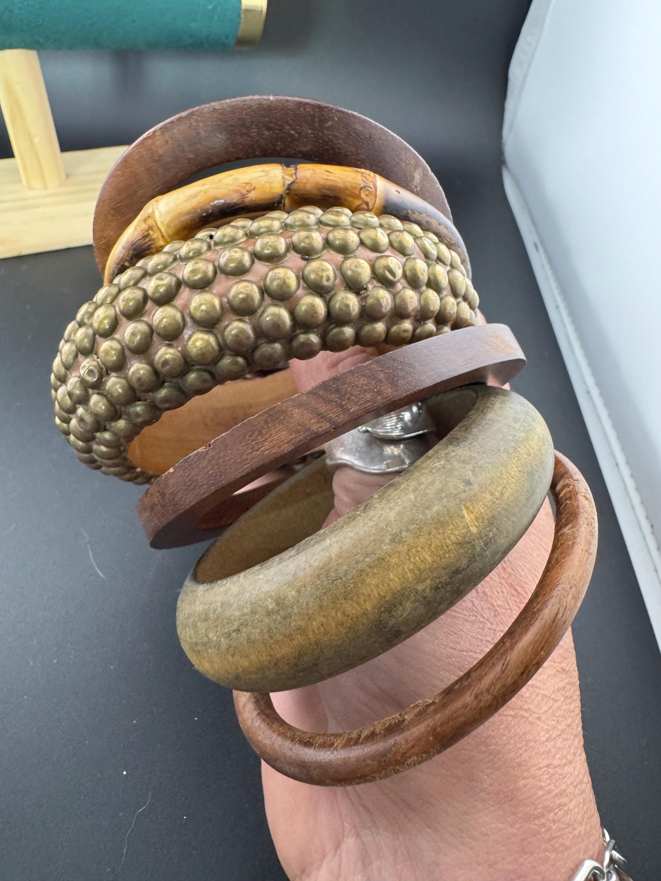 A curated stack of vintage retro wooden stacking bangles in brown natural shades ethnic tribal boho festival bracelets