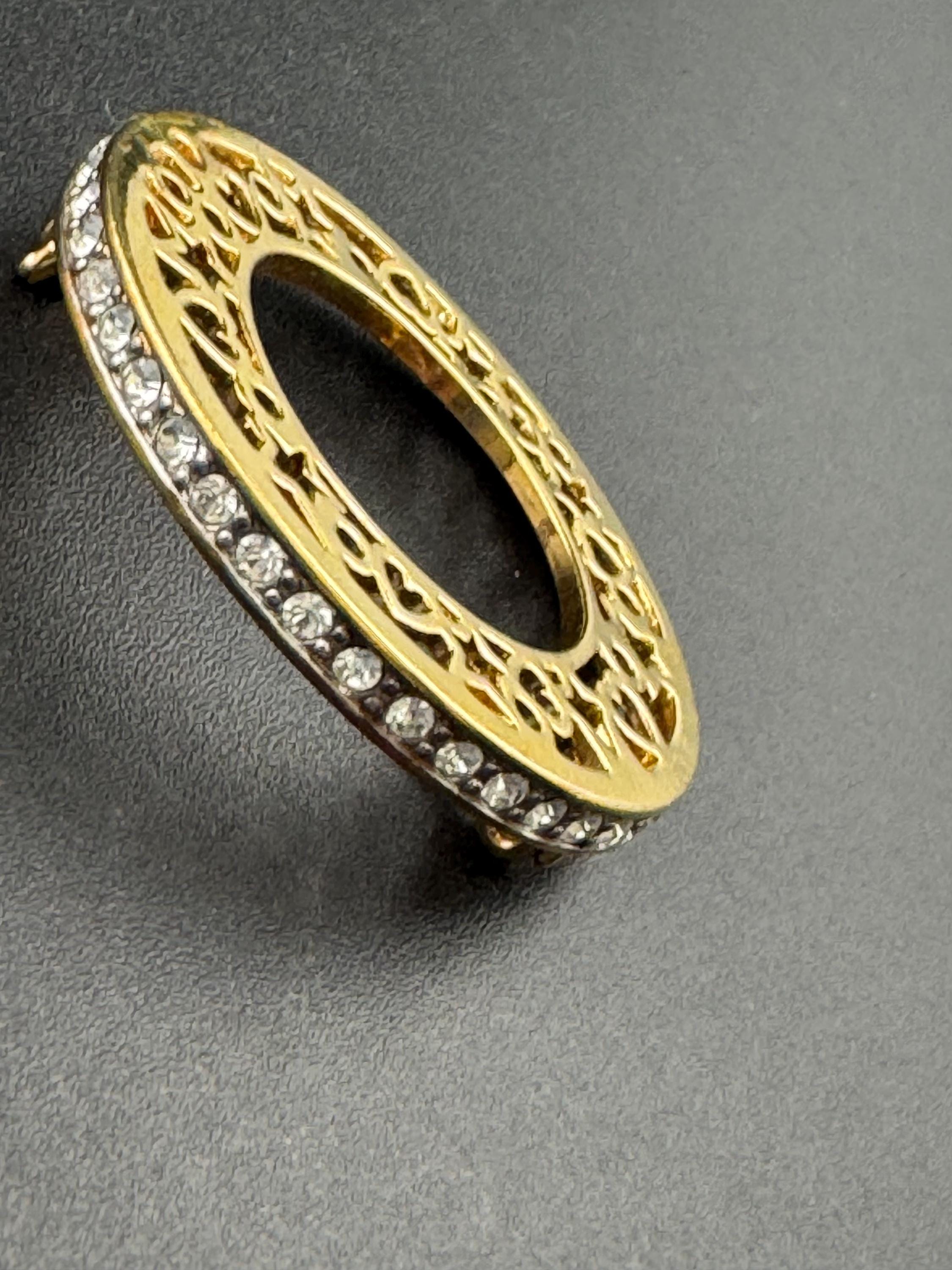 Vintage round openwork gold tone brooch channel set with clear rhinestones , sleek modernist design