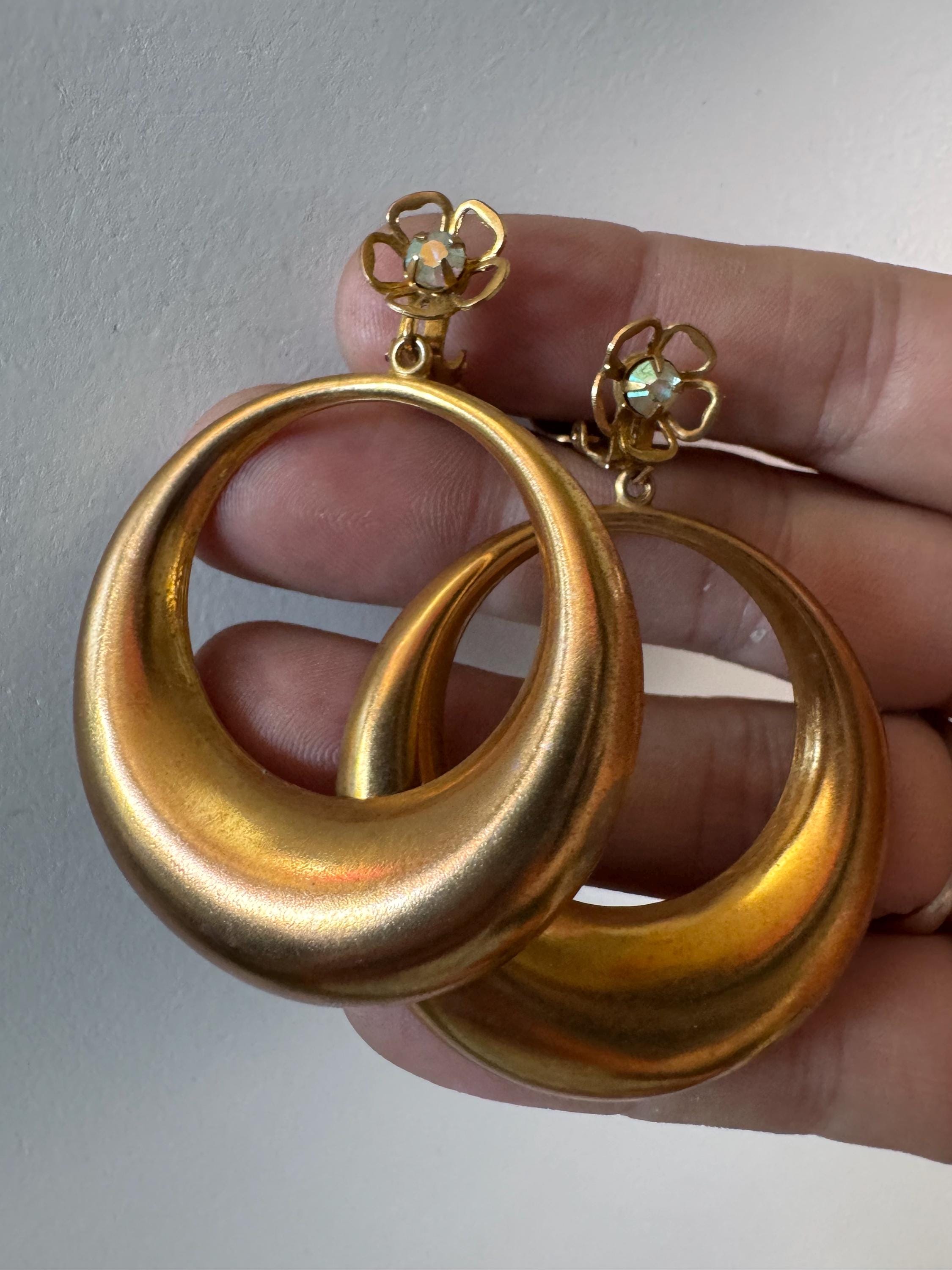 Vintage 1960s brass gold tone big loop clip on earrings set with aurora borealis rhinestone.