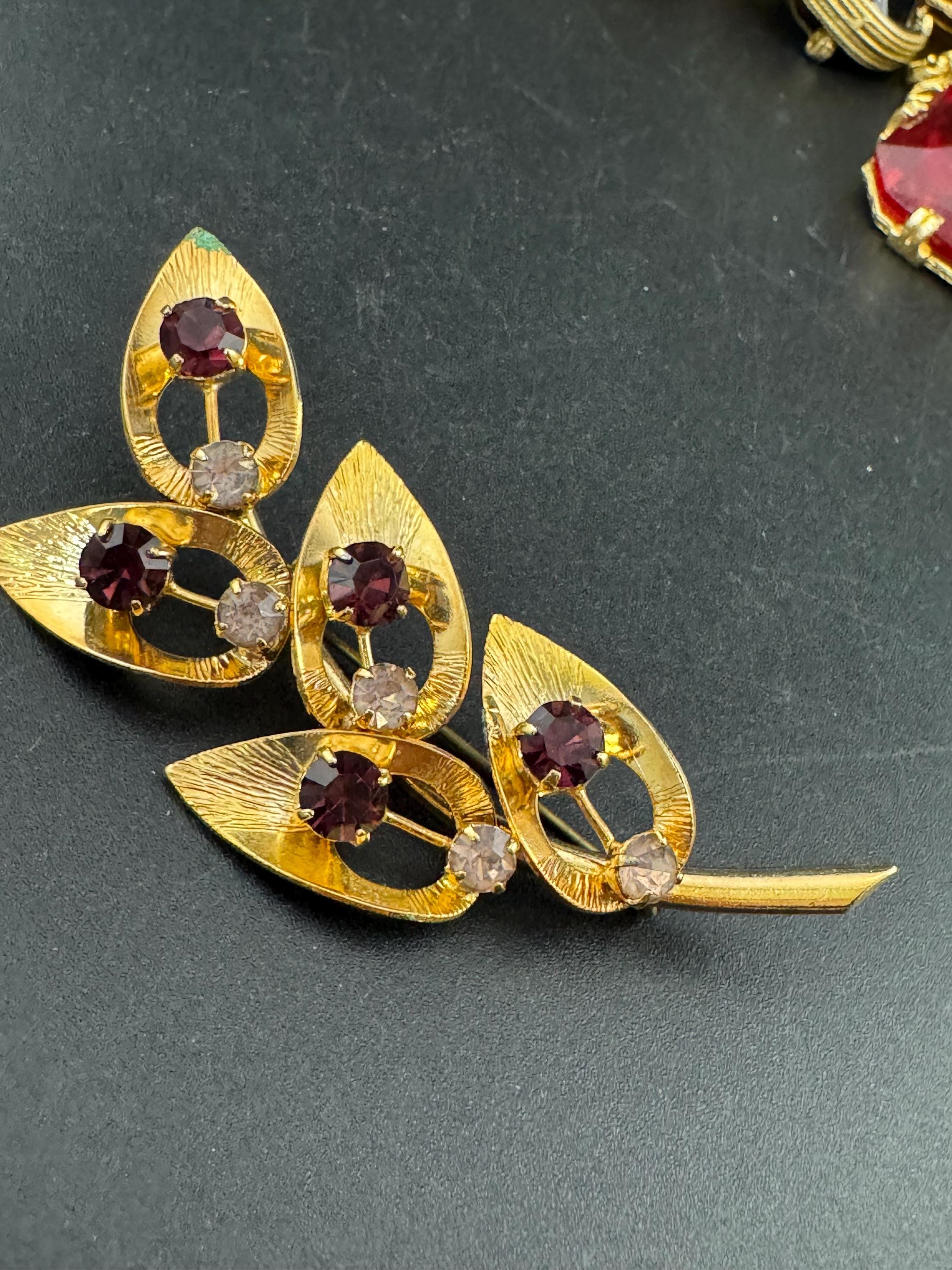 Vintage dark amethyst purple glass rhinestone gold plated floral brooch , mid century