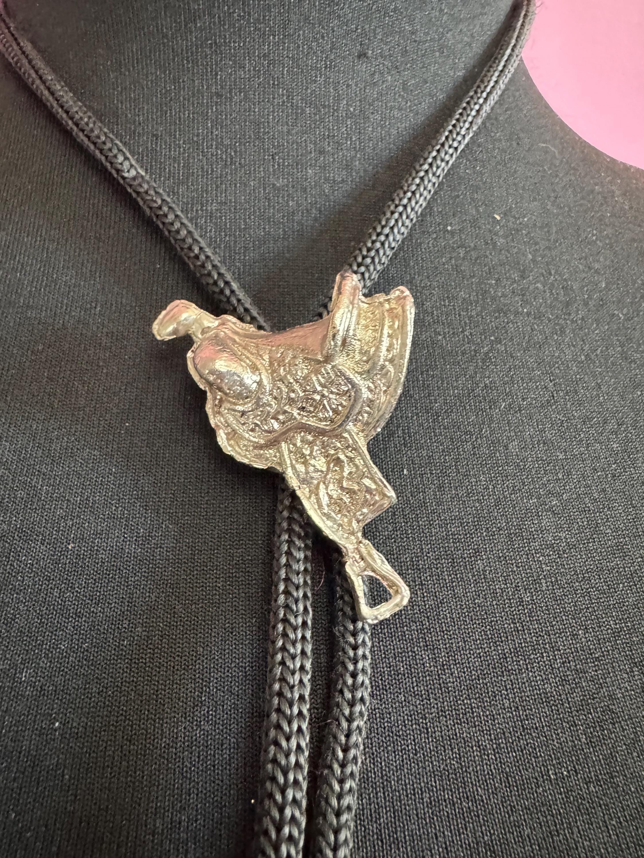 Retro western style horse saddle bolo tie with black woven leather