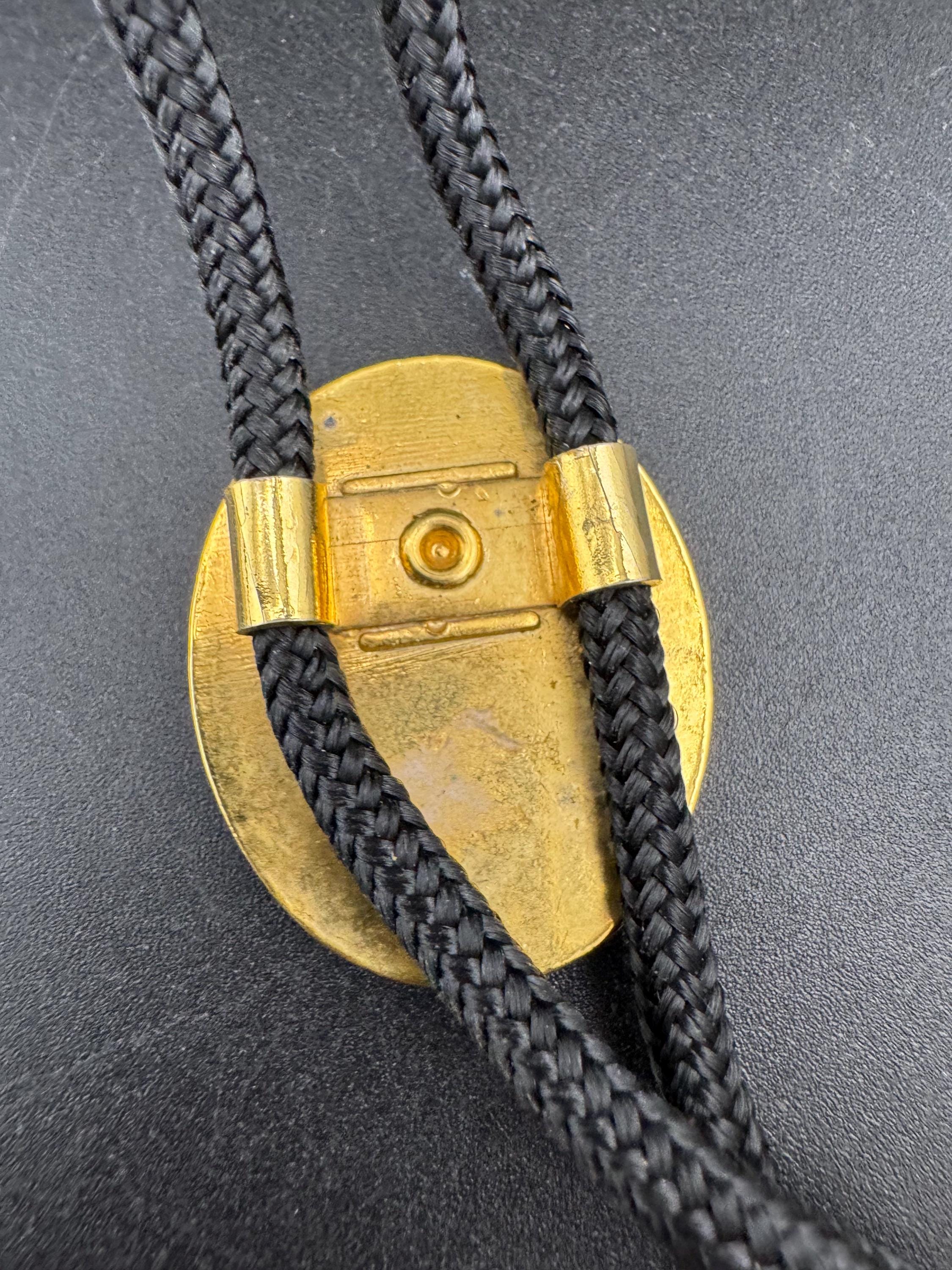 Retro western style gold black enamel horse saddle bolo tie with black woven cord