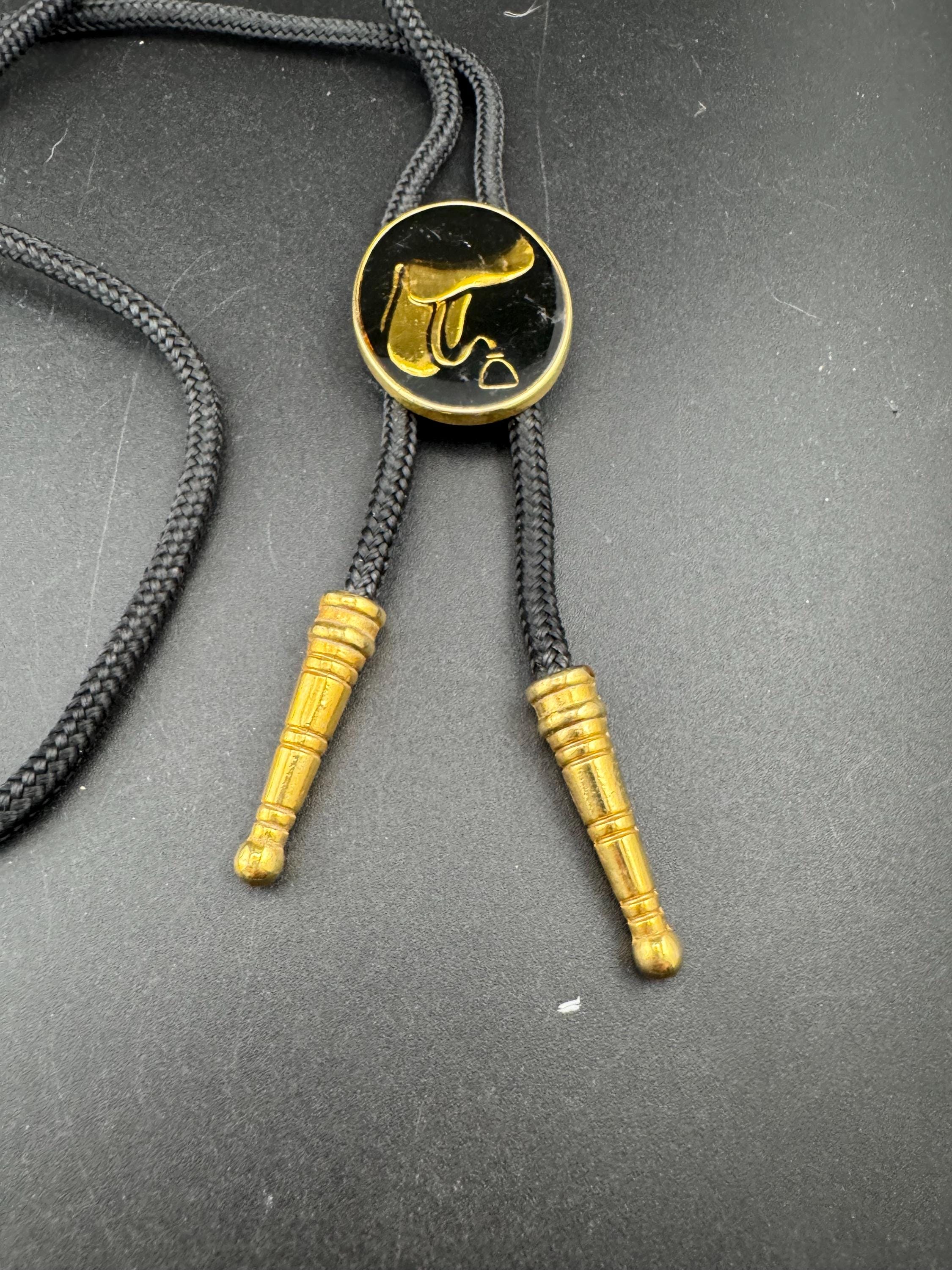 Retro western style gold black enamel horse saddle bolo tie with black woven cord