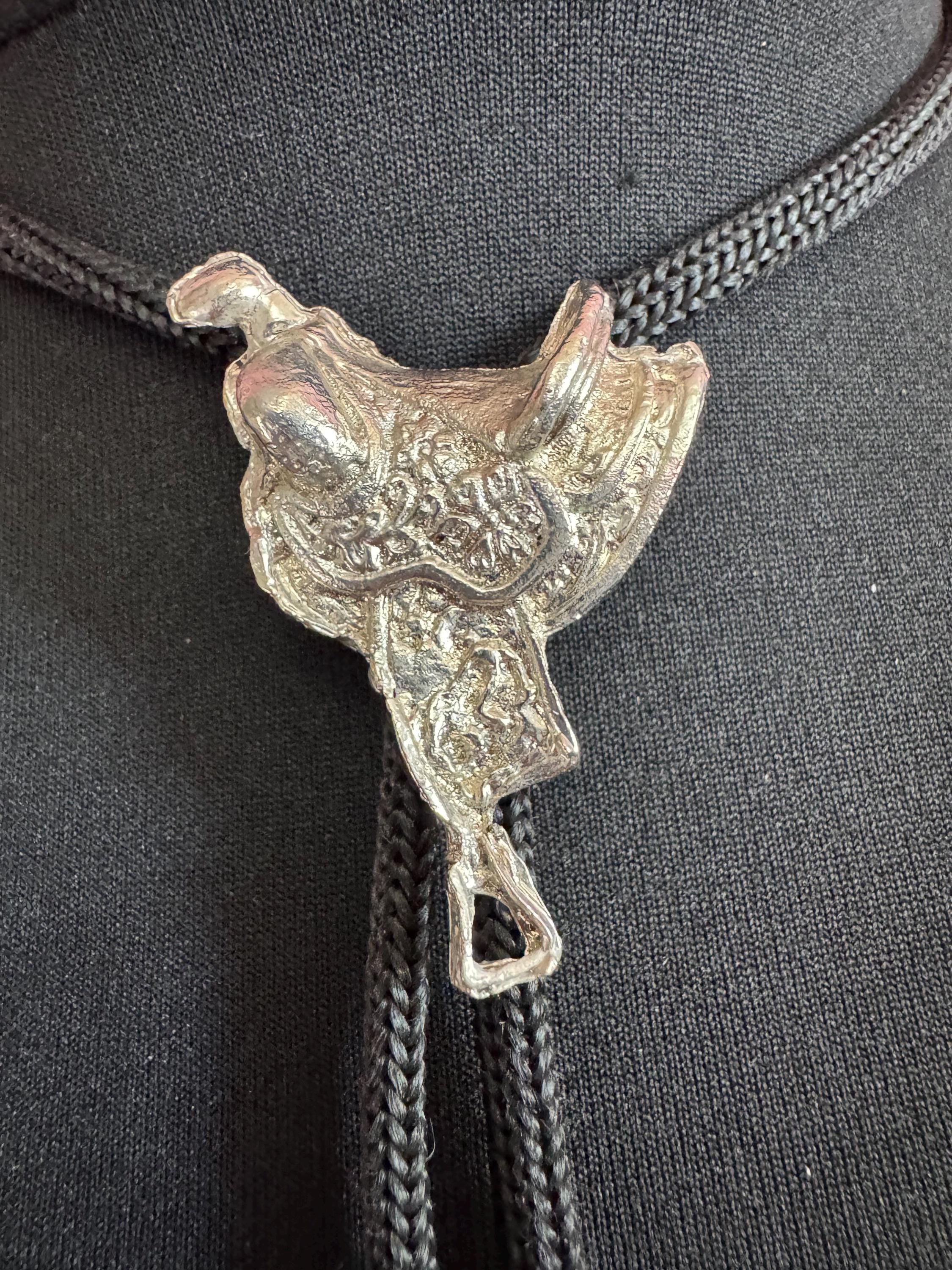 Retro western style horse saddle bolo tie with black woven leather