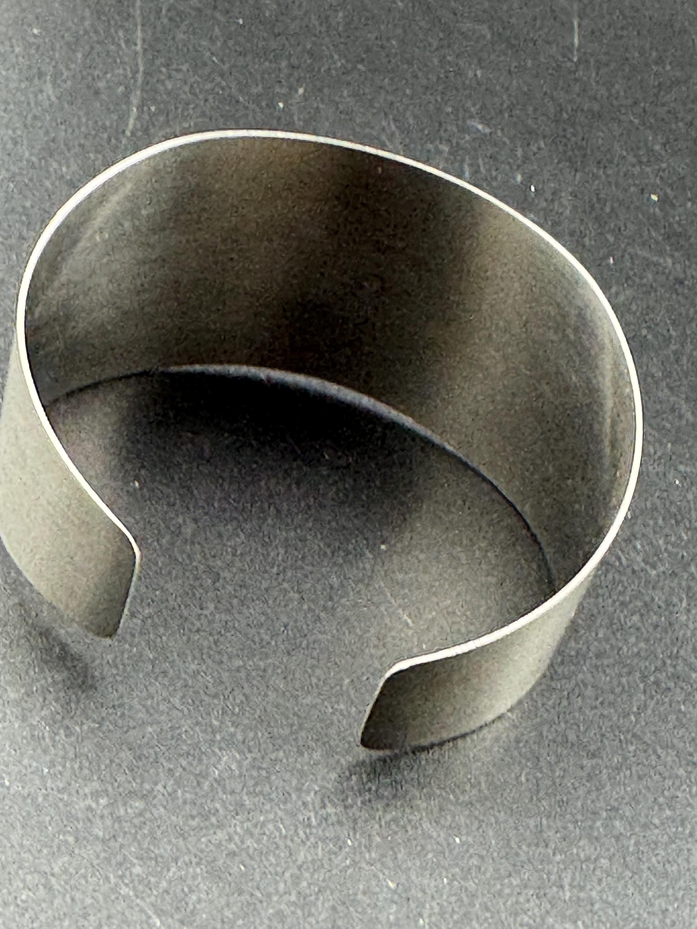 1970s stainless steel bangle, set with purple shell cabochon