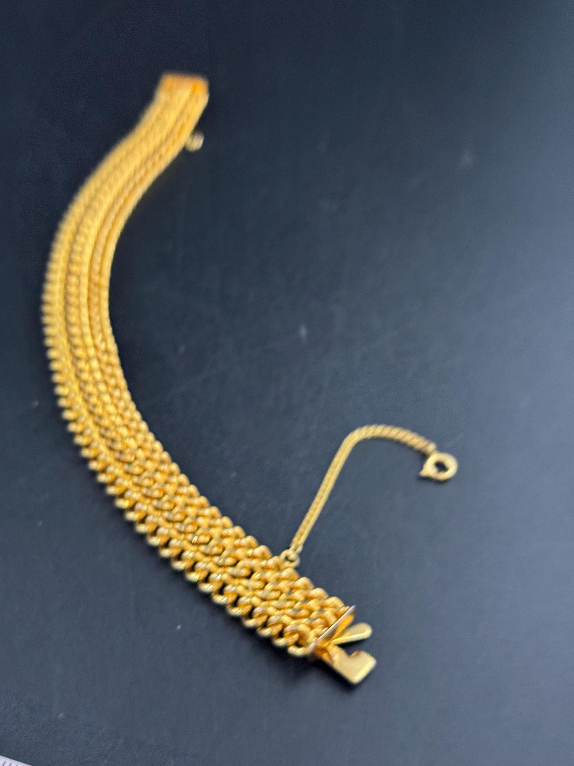 bright gold tone wide woven curb chain bracelet , with safety chain