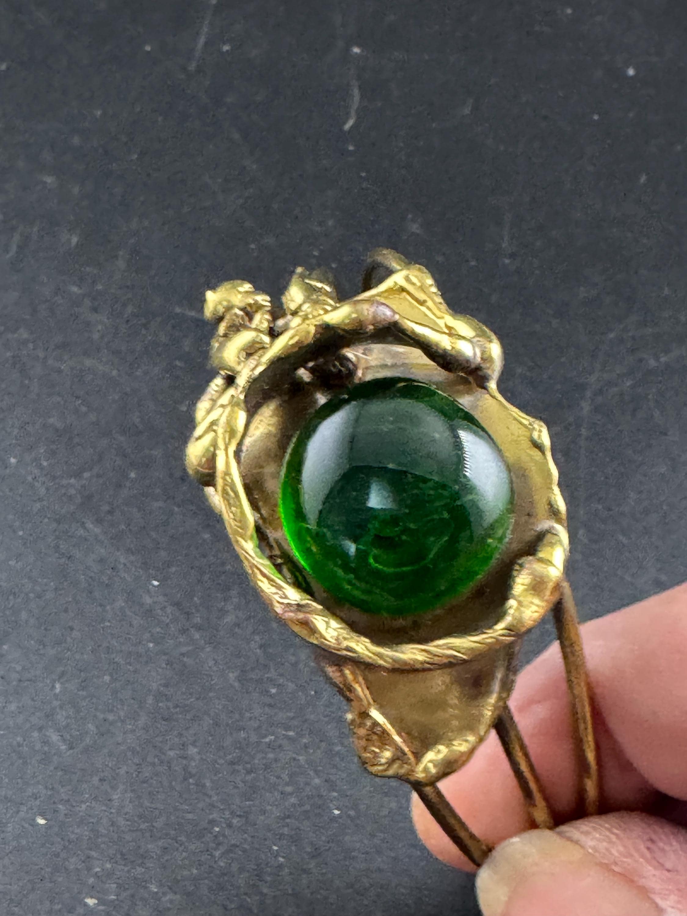 Artisan brass open bangle, set with green glass cabochon