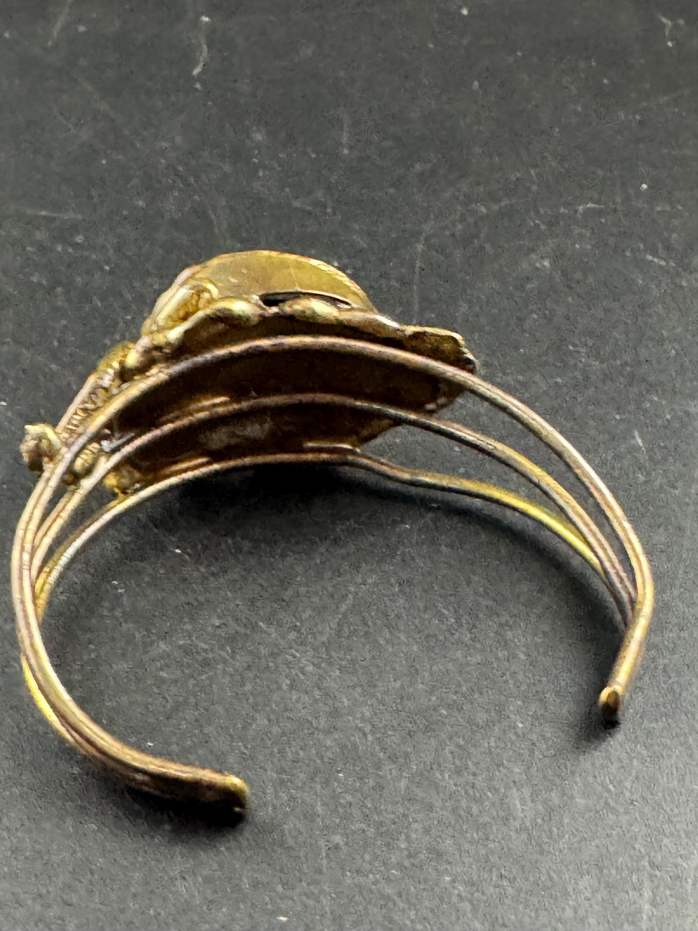 Artisan brass open bangle, set with green glass cabochon