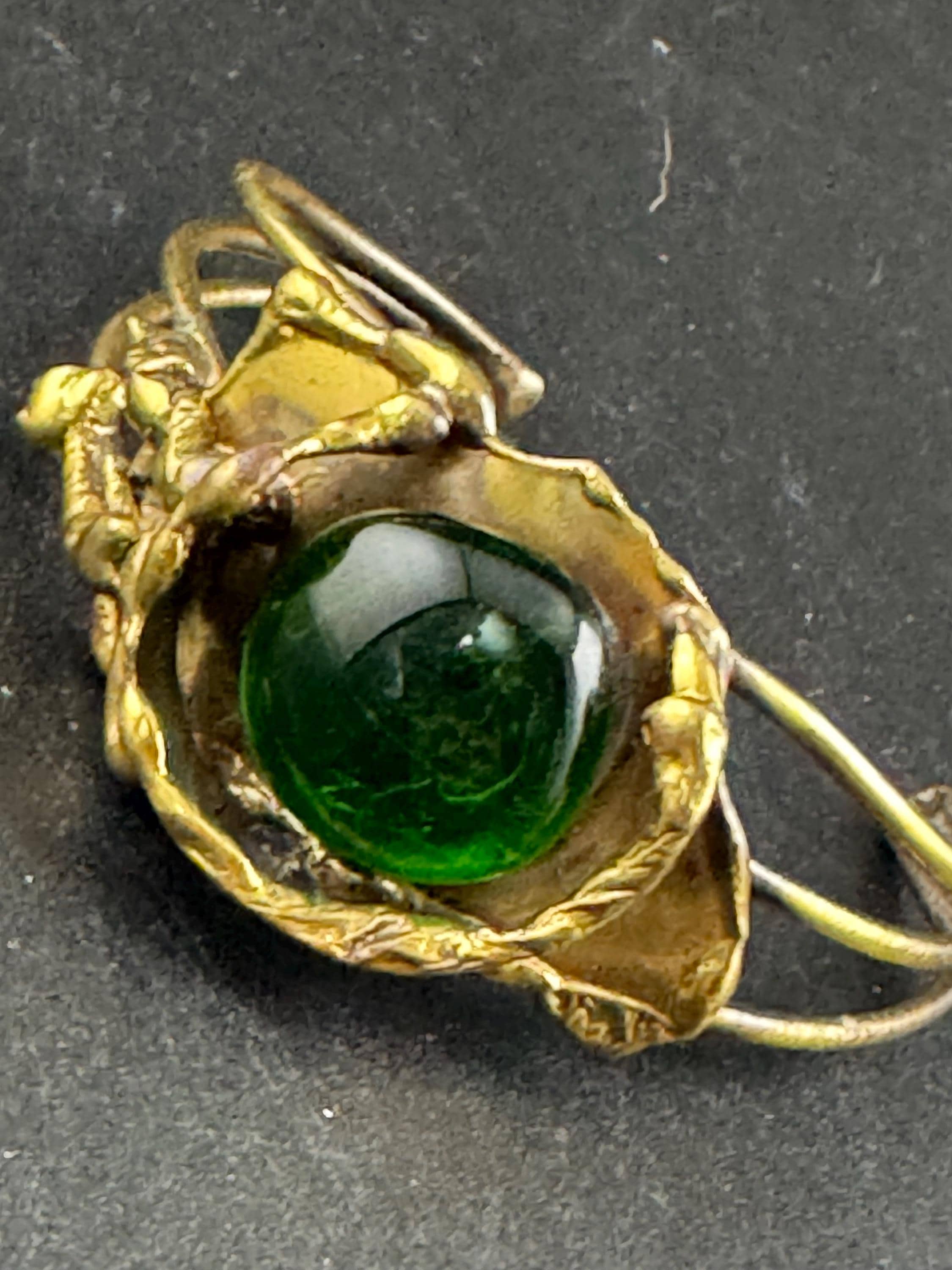 Artisan brass open bangle, set with green glass cabochon