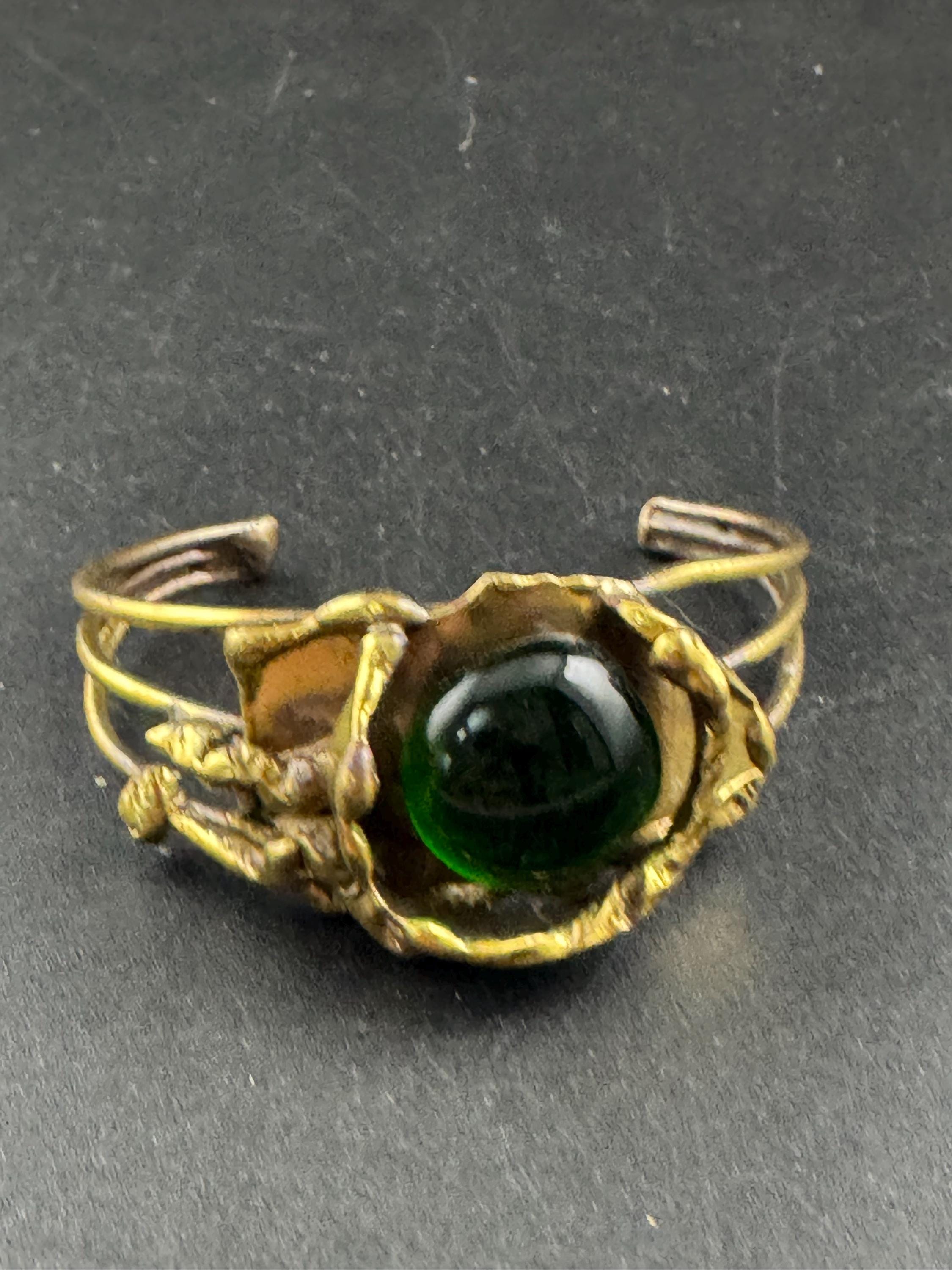 Artisan brass open bangle, set with green glass cabochon