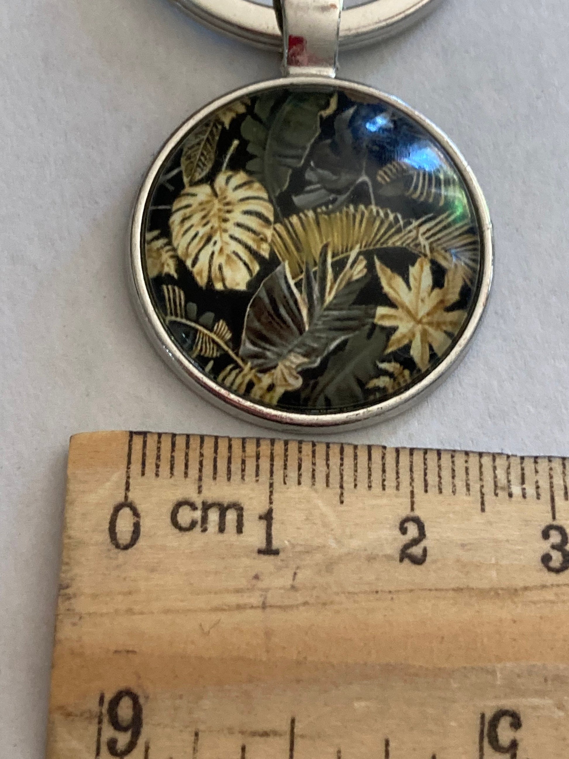 Designer style black and gold palm tree print silver tone keyring with 25mm glass cabochon